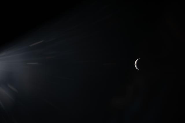 An illuminated sliver of Earth set against the blackness of...