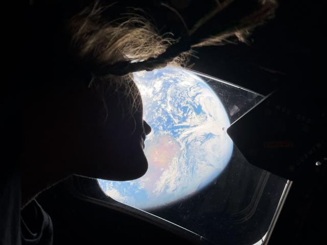 NASA astronaut and Artemis II mission specialist Christina Koch peers out of ...