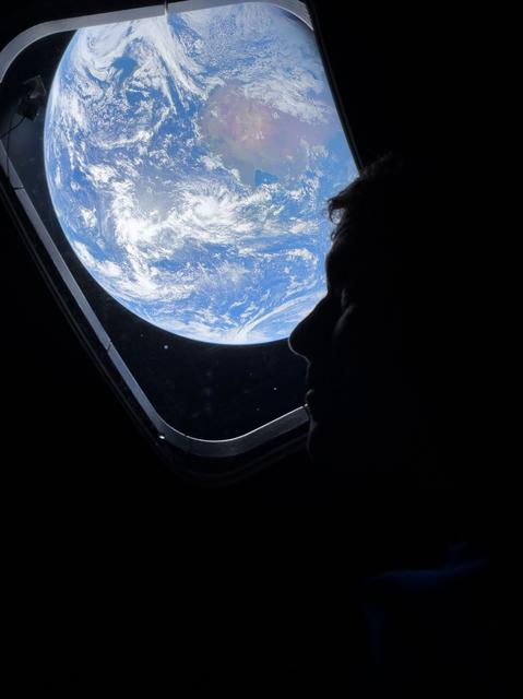 NASA astronaut and Artemis II Commander Reid Wiseman peers out of one of the ...