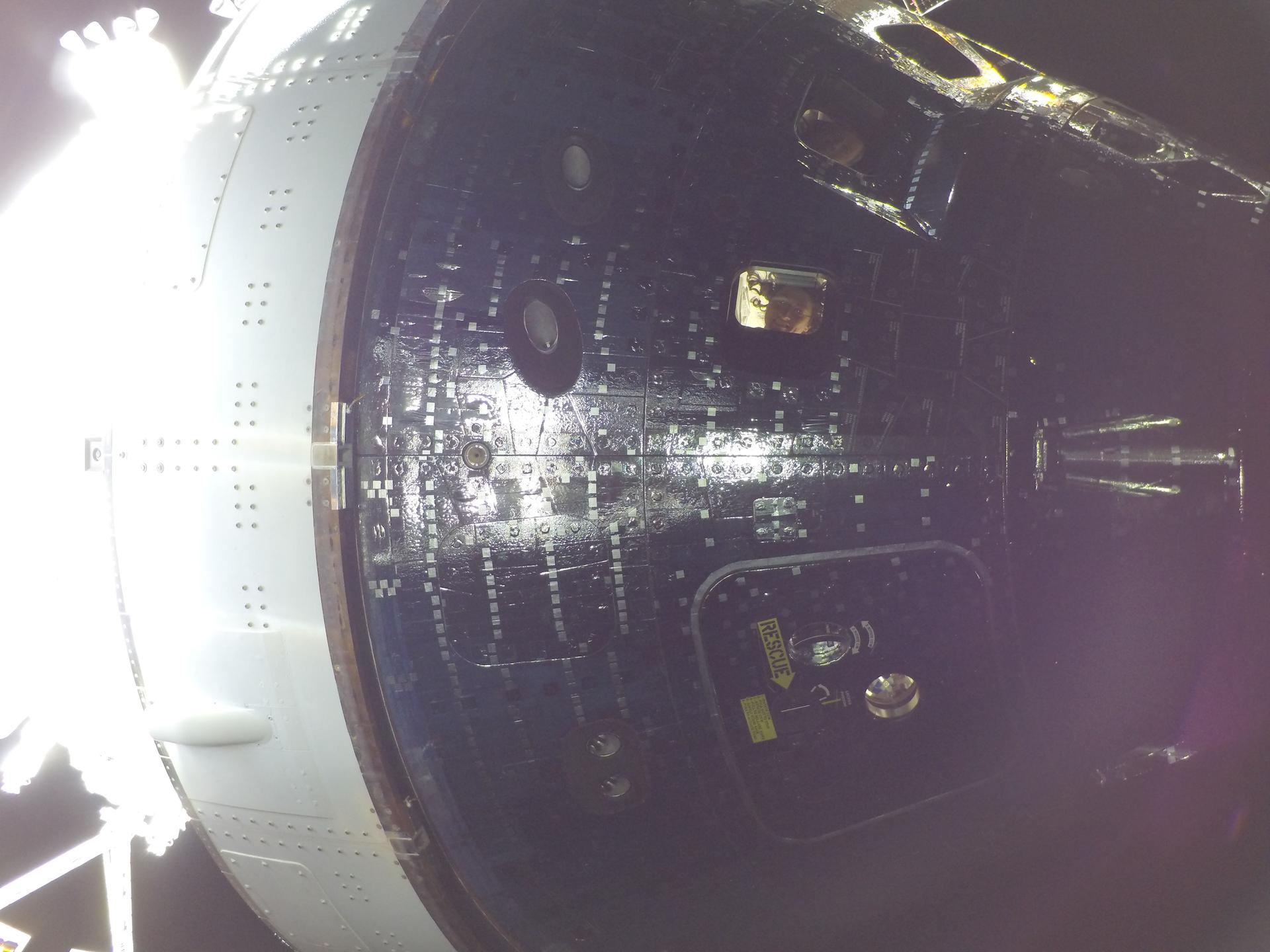 art002e009014 (April 4, 2026) - Artemis II Mission Specialist Christina Koch (center) and Commander Reid Wiseman (top) are seen through...