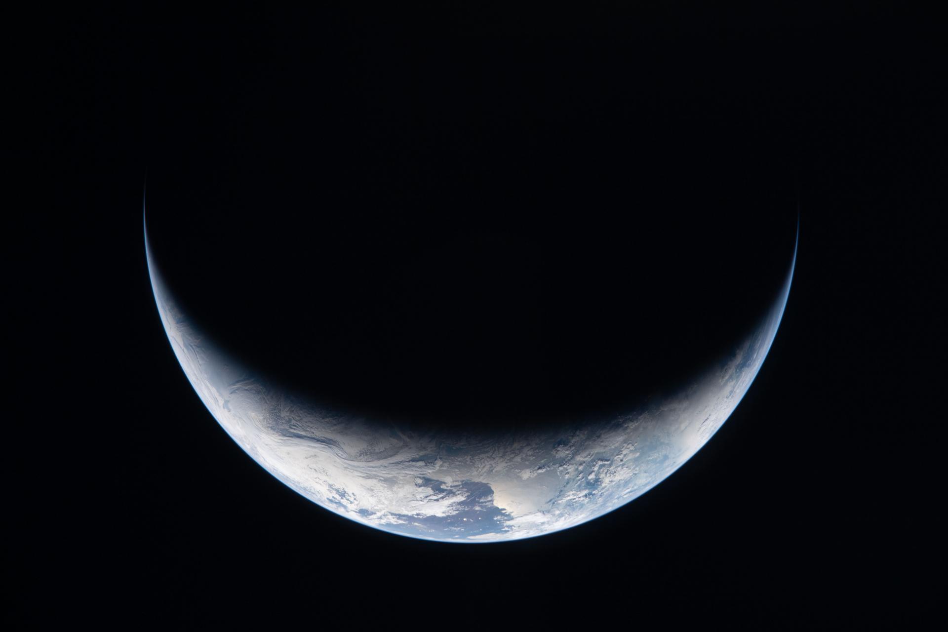 art002e009166 (April 3, 2026) - A sliver of Earth is illuminated against the blackness of space in this photo taken...
