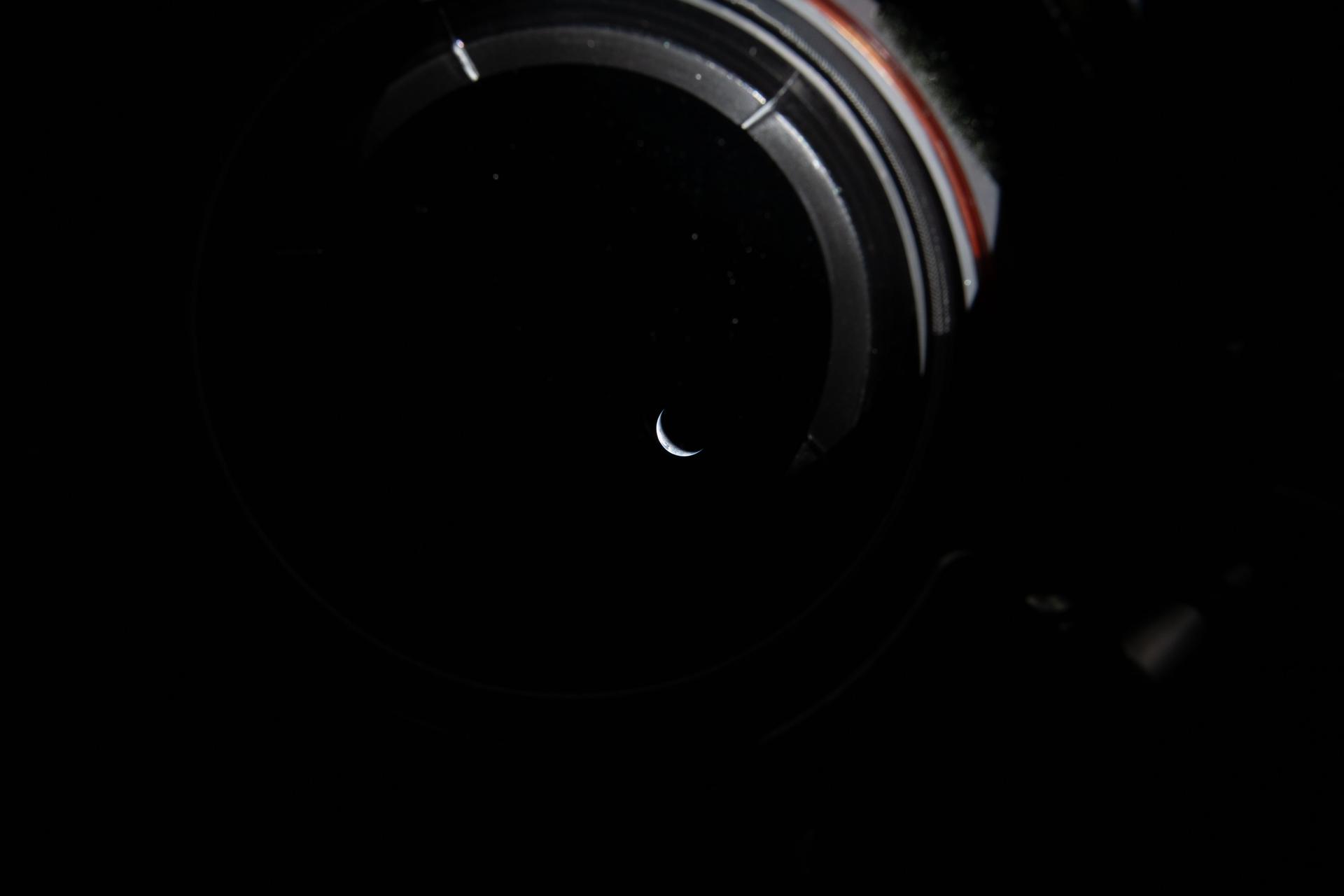 art002e009174 (April 3, 2026) - Peering out the window of the Orion spacecraft at a sliver of the Earth illuminated...