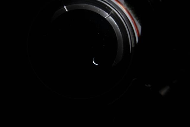 Peering out the window of the Orion spacecraft at a sliver of...