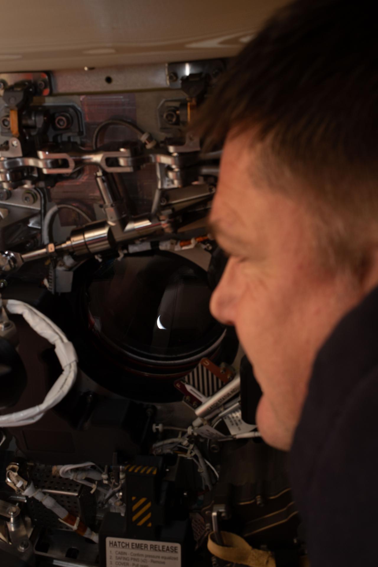 art002e009272 (April 6, 2026) - Artemis II mission specialist and CSA (Canadian Space Agency) astronaut Jeremy Hansen peers out one...