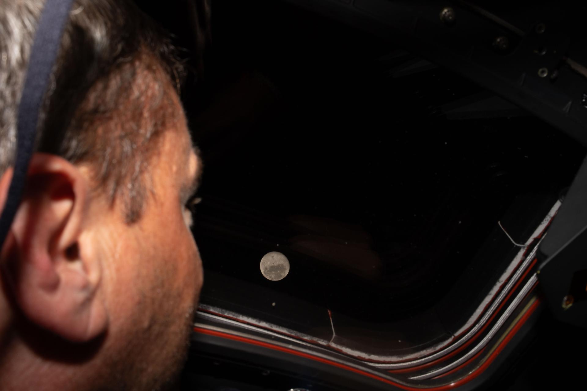 art002e009275 (April 6, 2026) - Artemis II commander and NASA astronaut Reid Wiseman looks out one of the Orion spacecraft's...