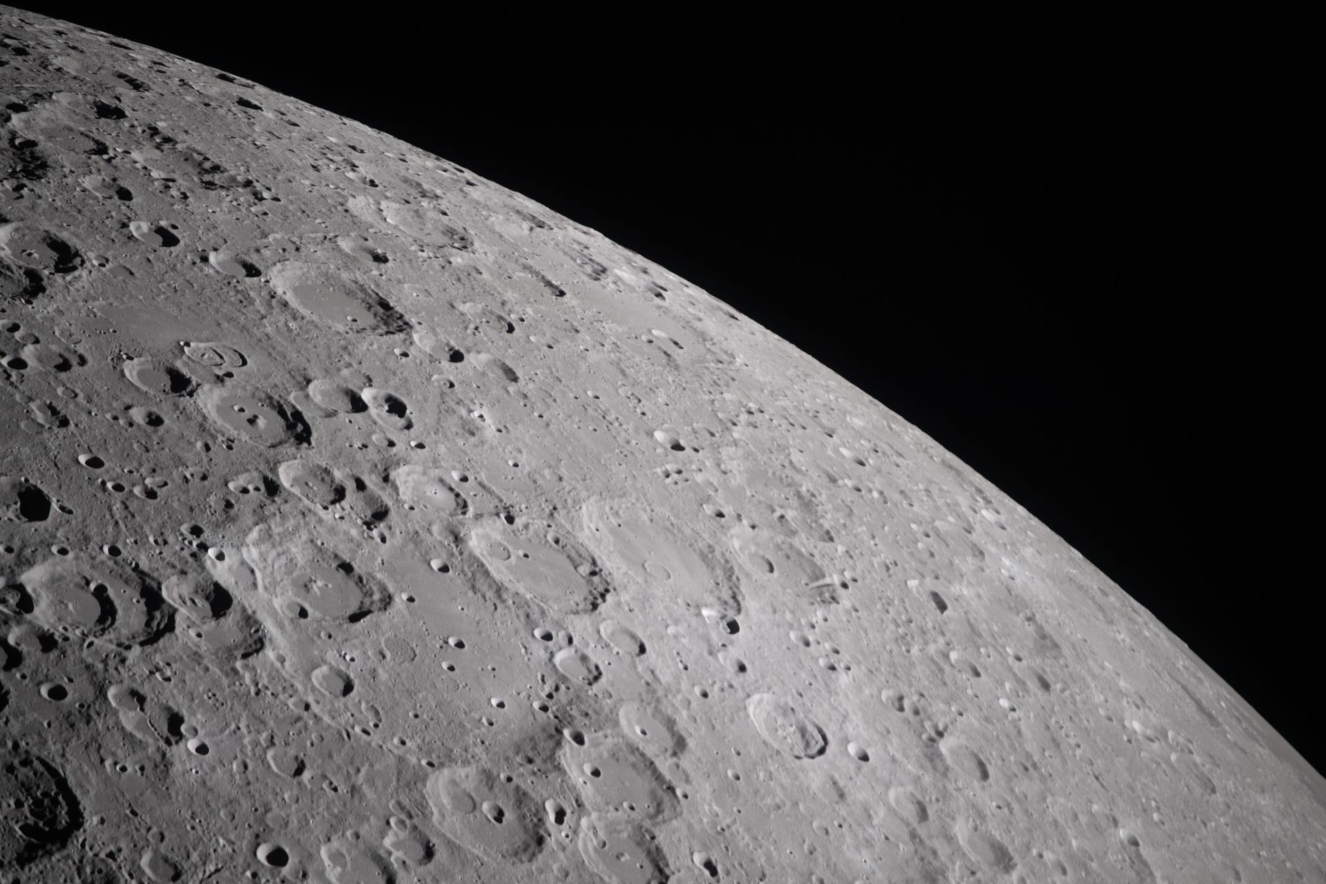 During a lunar flyby observation period, the Artemis II crew captures craters dotting the surface of the Moon, revealing its rugged, ancient surface. This scarred landscape reflects a long history of cosmic collisions.