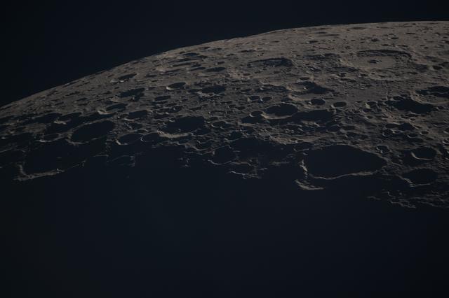 A close-up view of the Moon along the terminator—the boundary...