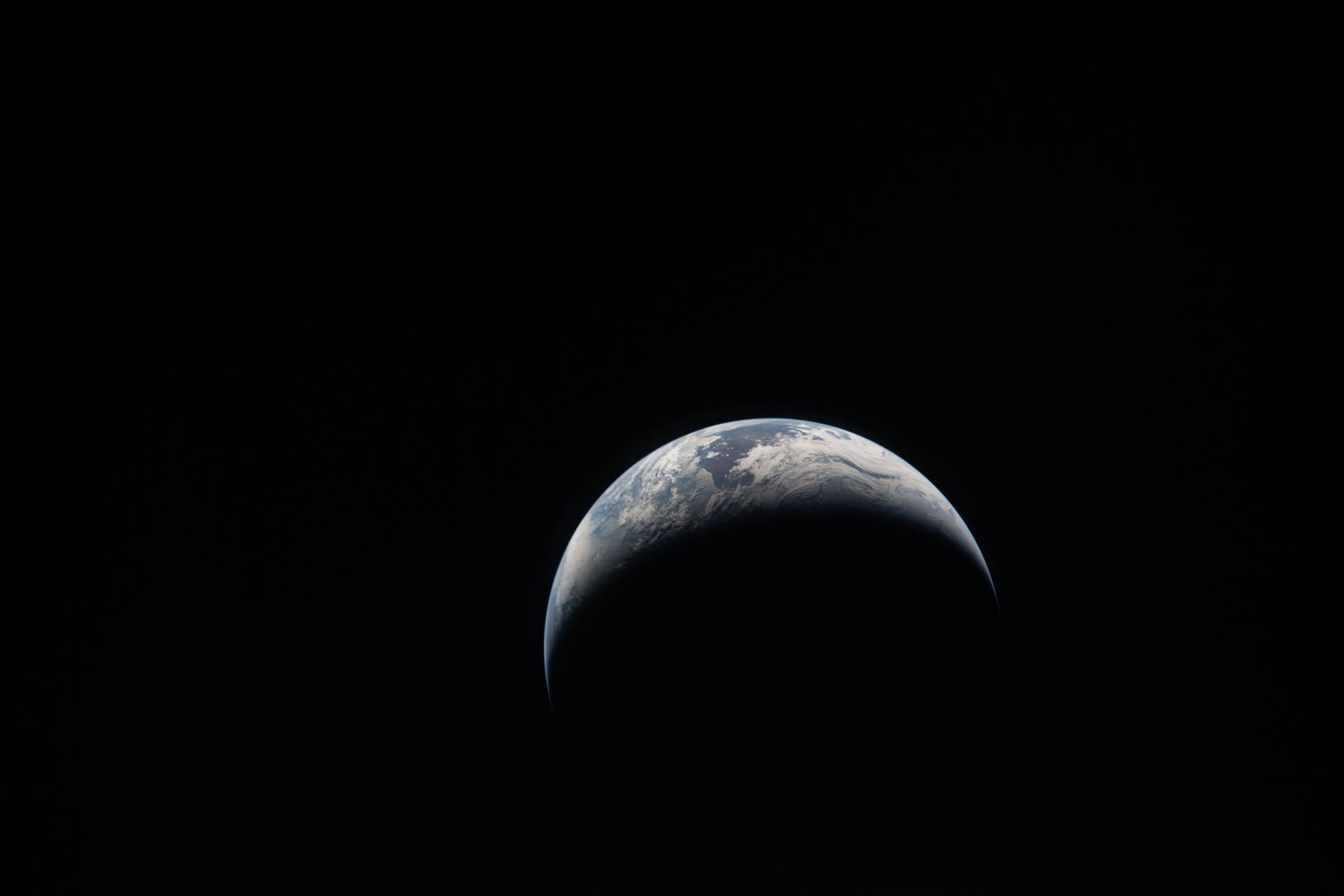 art002e014066 (April 6, 2026) – The Artemis II crew captures an image of a crescent Earth on their journey around the Moon.