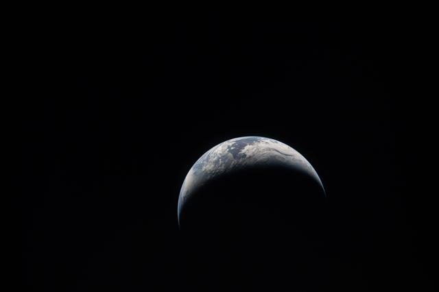 The Artemis II crew captures an image of a crescent Earth on...