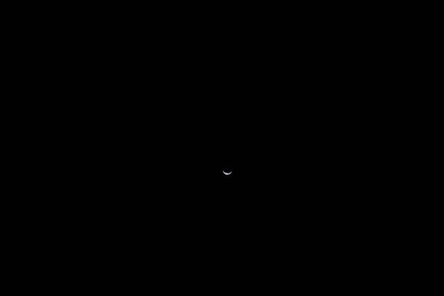 Seen from afar, Earth appears as a small, delicate waning...