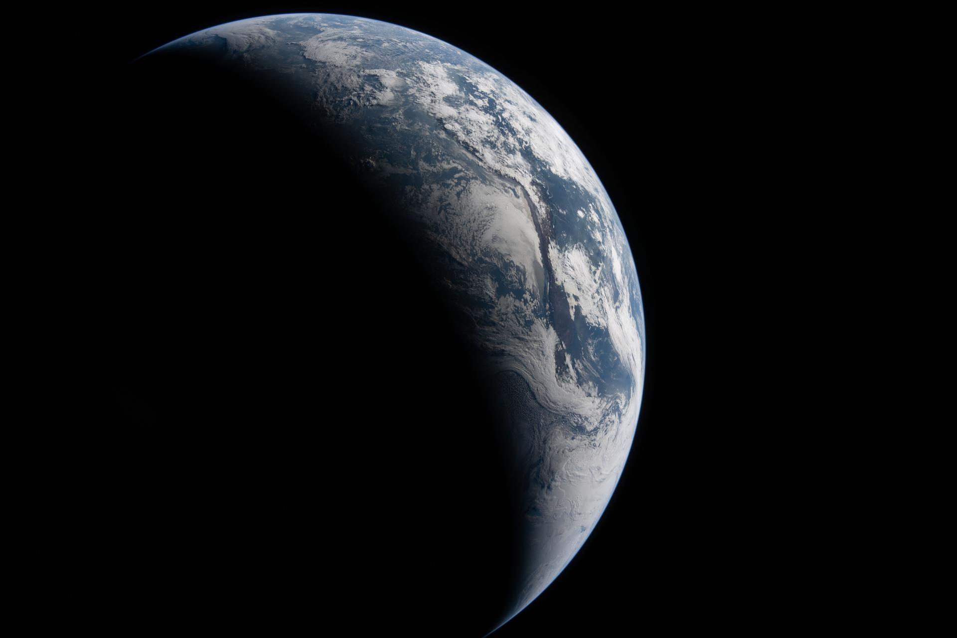 art002e023314 (April 2, 2026) – The Artemis II crew captured this view of Earth from approximately 43,500 miles (70,000 kilometers) away. Sunlight illuminates a portion of the planet while much of Earth remains in shadow, creating a curved boundary between day and night. South America is prominent in the sunlit portion, where the Atacama Desert, Andes Mountains, cloud formations, and other surface features are visible against the darkness of space. Credit: NASA