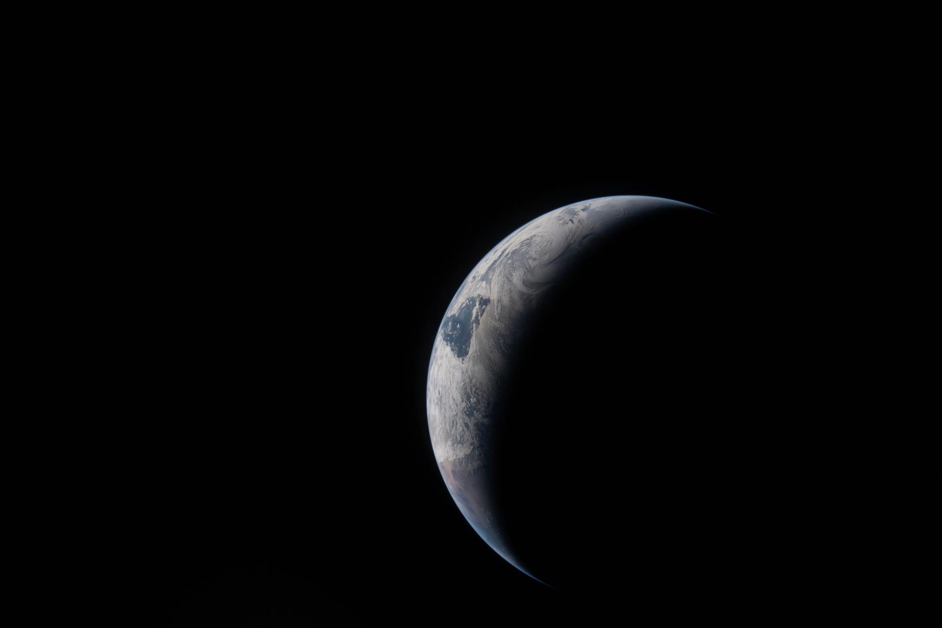 art002e024014 (April 4, 2026) - A thin arc glowing in the darkness of space. Sunlight traces the curves of the...