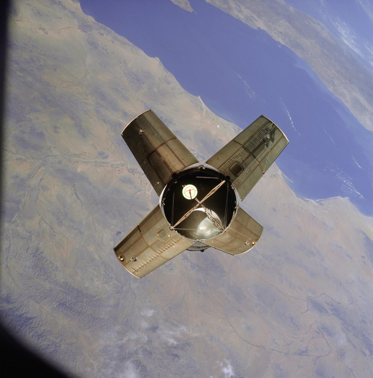 AS07-03-1531 (11 Oct. 1968) --- The expended Saturn IVB stage as photographed from the Apollo 7 spacecraft during transposition and docking maneuvers. This photograph was taken over Sonora, Mexico, during Apollo 7's second revolution of Earth. The round, white disc inside the open panels of the Saturn IVB is a simulated docking target similar to that used on the lunar module for docking during lunar missions.