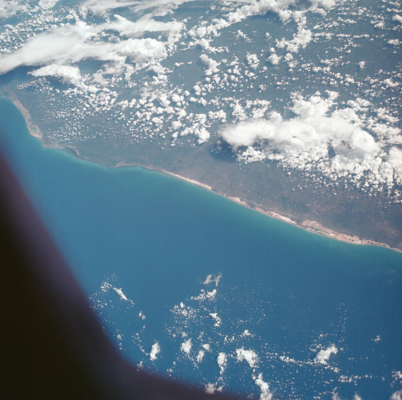 AS07-05-1635 (13 Oct. 1968) --- Gulf of Mexico, coast of Yucatan, Mexico, as seen from the Apollo 7 spacecraft during its 33rd revolution of Earth. Note road leading to city of Merida which is under cloud cover. Photographed from an altitude of 123 nautical miles, at ground elapsed time of 52 hours and 37 minutes.
