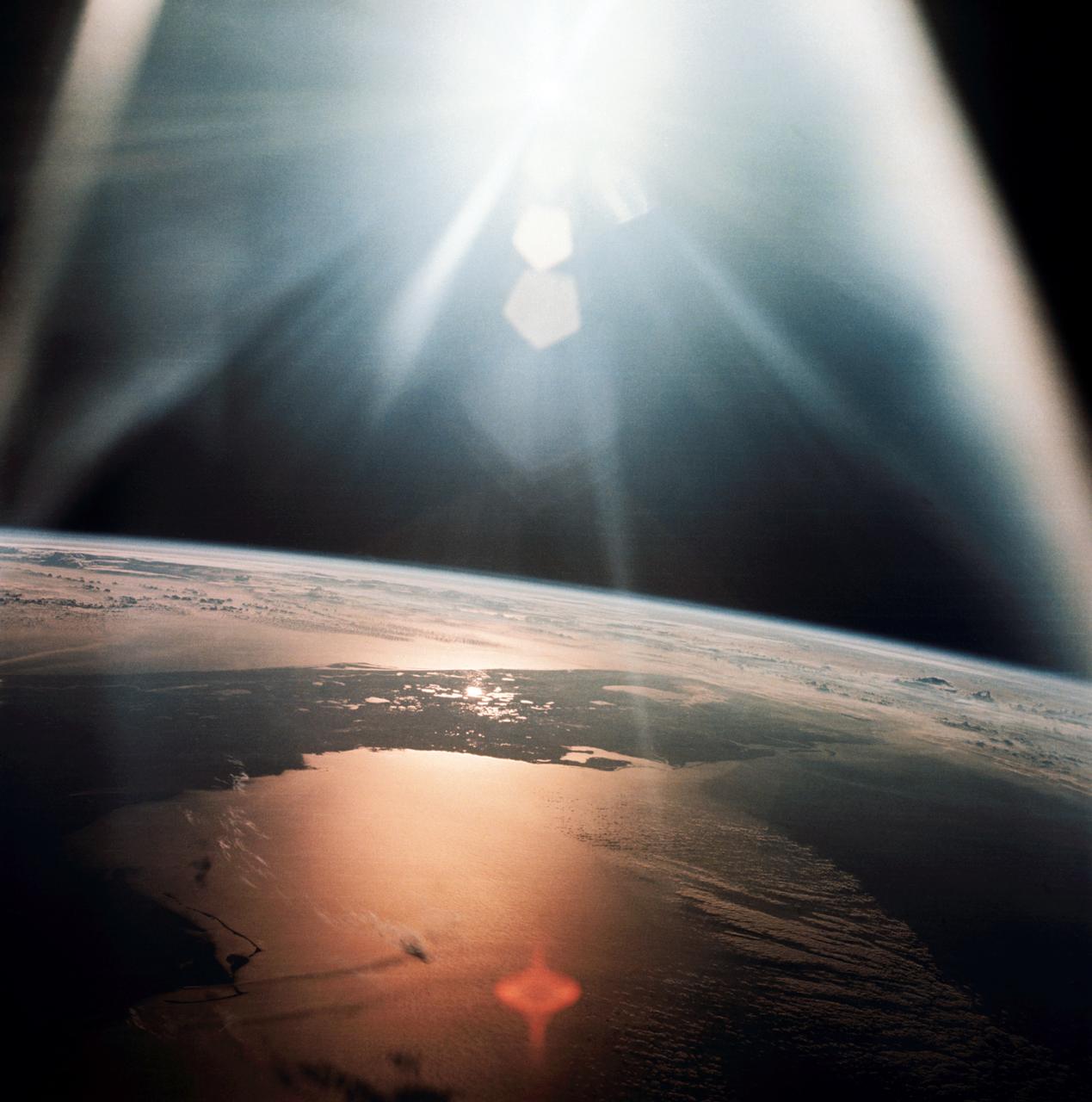 AS07-08-1933 (20 Oct. 1968) --- The morning sun reflects on the Gulf of Mexico and the Atlantic Ocean as seen from the Apollo 7 spacecraft at an altitude of 120 nautical miles above Earth. Most of Florida peninsula appears as a dark silhouette. This photograph was made during the spacecraft's 134th revolution of Earth, some 213 hours and 19 minutes after liftoff.
