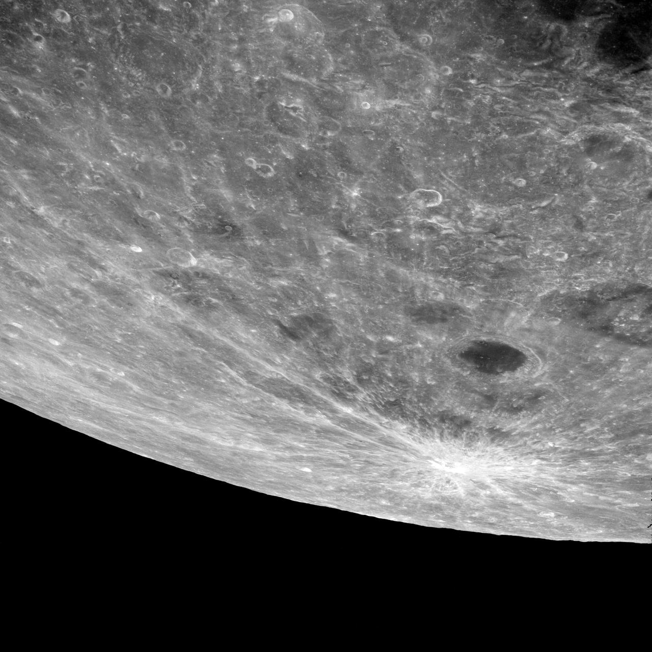 AS08-12-2209 (21-27 Dec. 1968) --- High altitude oblique view of the lunar surface, looking northeastward, as seen from the Apollo 8 spacecraft. The crater Joliot-Curie, about 175 kilometers in diameter and centered near 94 degrees east longitude and 27 degrees north latitude, is near the center of the left side of this photograph. The bright rayed crater near the horizon is probably located near 105 degrees east longitude and 45 degrees north latitude. Long, narrow rays that have been reported in the polar region of Earth facing hemisphere may radiate from this crater.