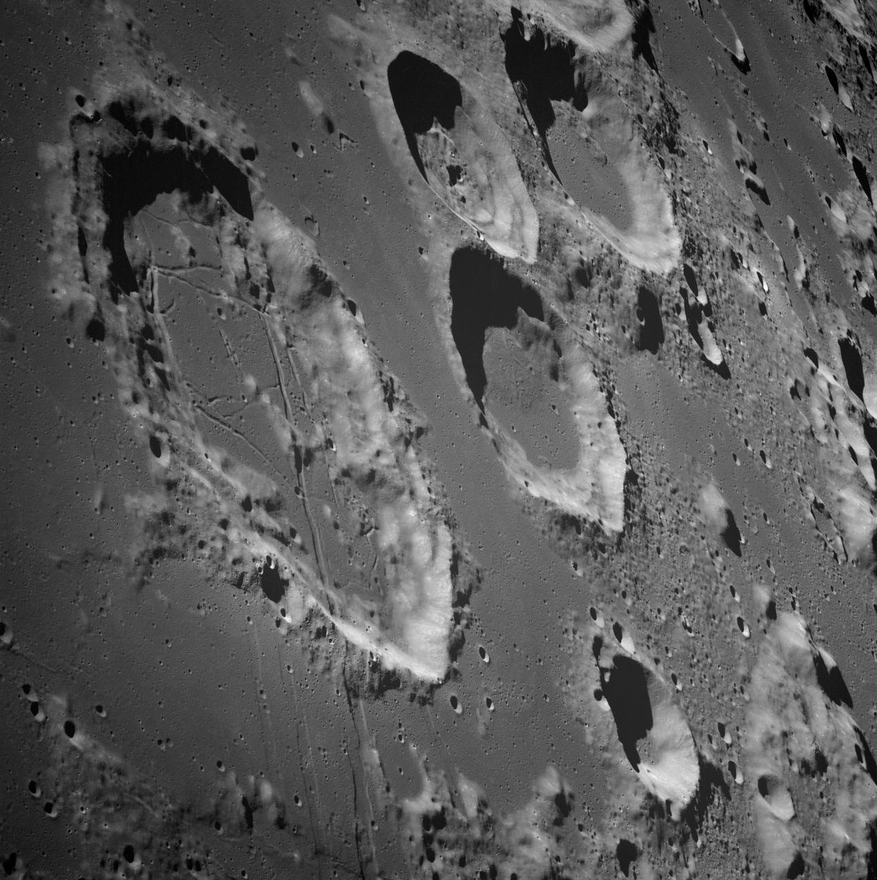 AS08-13-2225 (21-27 Dec. 1968) --- This photograph was taken from the Apollo 8 spacecraft with long-focal length lens, looking south at the large crater Goclenius, which is in foreground. Hold picture with Goclenius at bottom center. The three clustered craters are Magelhaens, Magelhaens A, and Colombo A. The crater at upper right is Gutenberg D. The crater Goclenius is located at 10 degrees south latitude, 45 degrees east longitude, and it is approximately 40 statute miles in diameter.