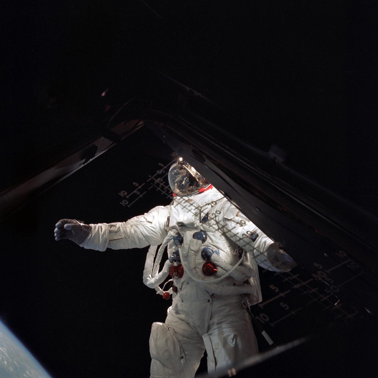 AS09-20-3094 (6 March 1969) --- Astronaut Russell L. Schweickart, lunar module pilot, stands in "golden slippers" on the Lunar Module porch during his extravehicular activity on the fourth day of the Apollo 9 Earth-orbital mission. This photograph was taken from inside the Lunar Module "Spider". The Command and Service Modules were docked to the LM. Schweickart is wearing an Extravehicular Mobility Unit (EMU). Inside the "Spider" was astronaut James A. McDivitt, Apollo 9 crew commander. Astronaut David R. Scott, command module pilot, remained at the controls of the Command Module, "Gumdrop."