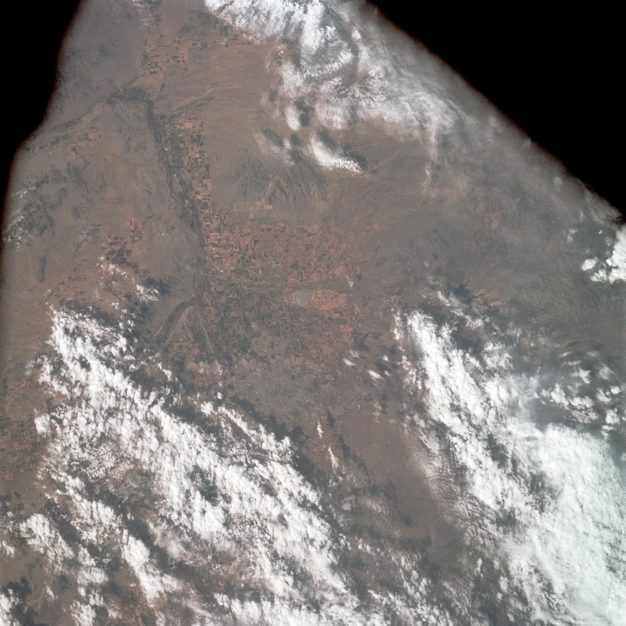 AS09-22-3441 (March 1969) --- Near vertical view of the Phoenix, Arizona area as photographed from the Apollo 9 spacecraft during its Earth-orbital mission. Farmland patterns checkerboard the area along the Gila River. Phoenix is located right of center near the clouds.