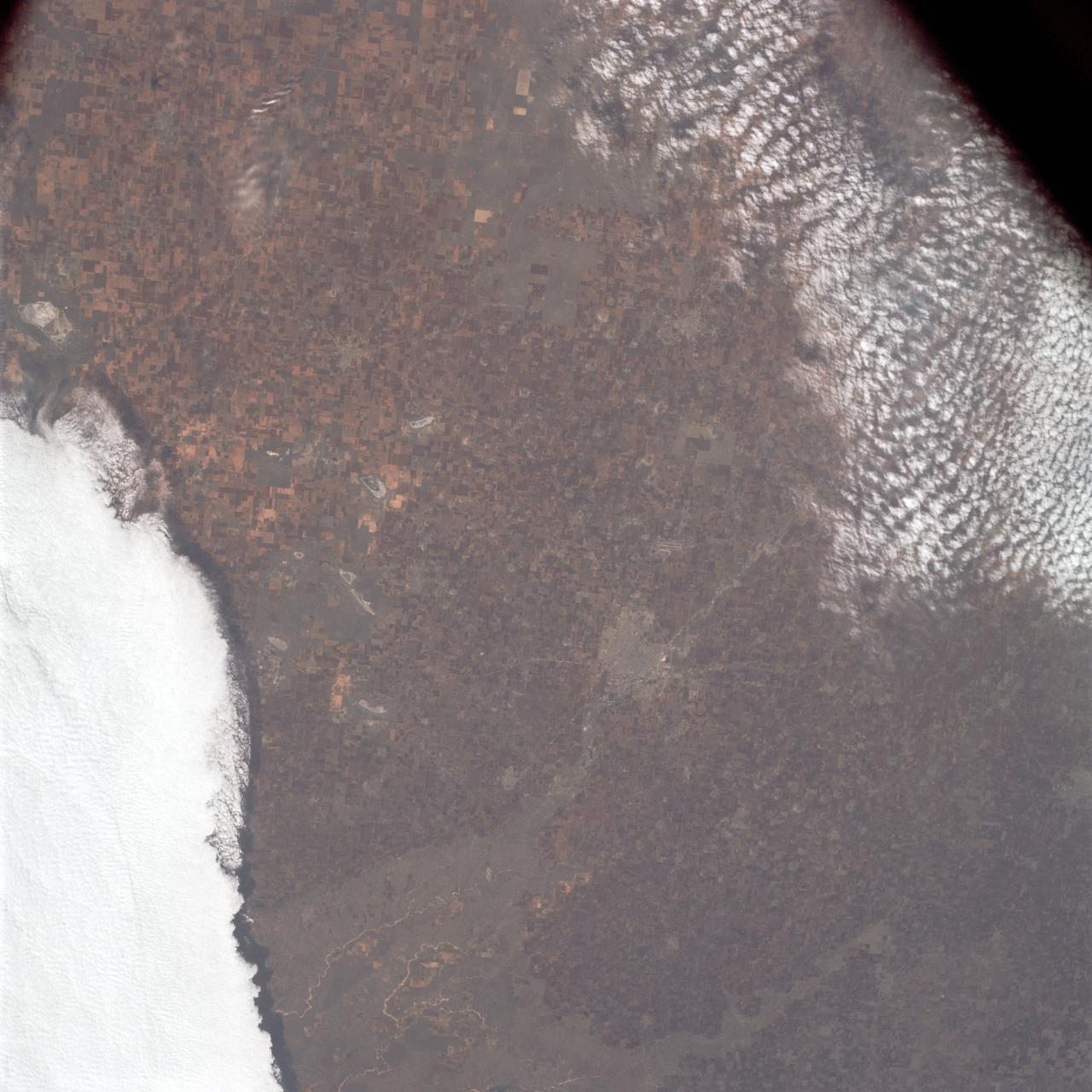 AS09-23-3561 (3-13 March 1969) --- Near vertical view of the Lubbock area in west Texas as photographed from the Apollo 9 spacecraft during its Earth-orbital mission. Conspicuous patterns of farmland surround the city and extend eastward (up) to the Caprock Escarpment. The Double Mountain fork of the Brazos River drains east (toward upper center); Leeland is at lower center; Brownfield at lower right. The sharp edge of a cloud disk cuts across the upper right corner.