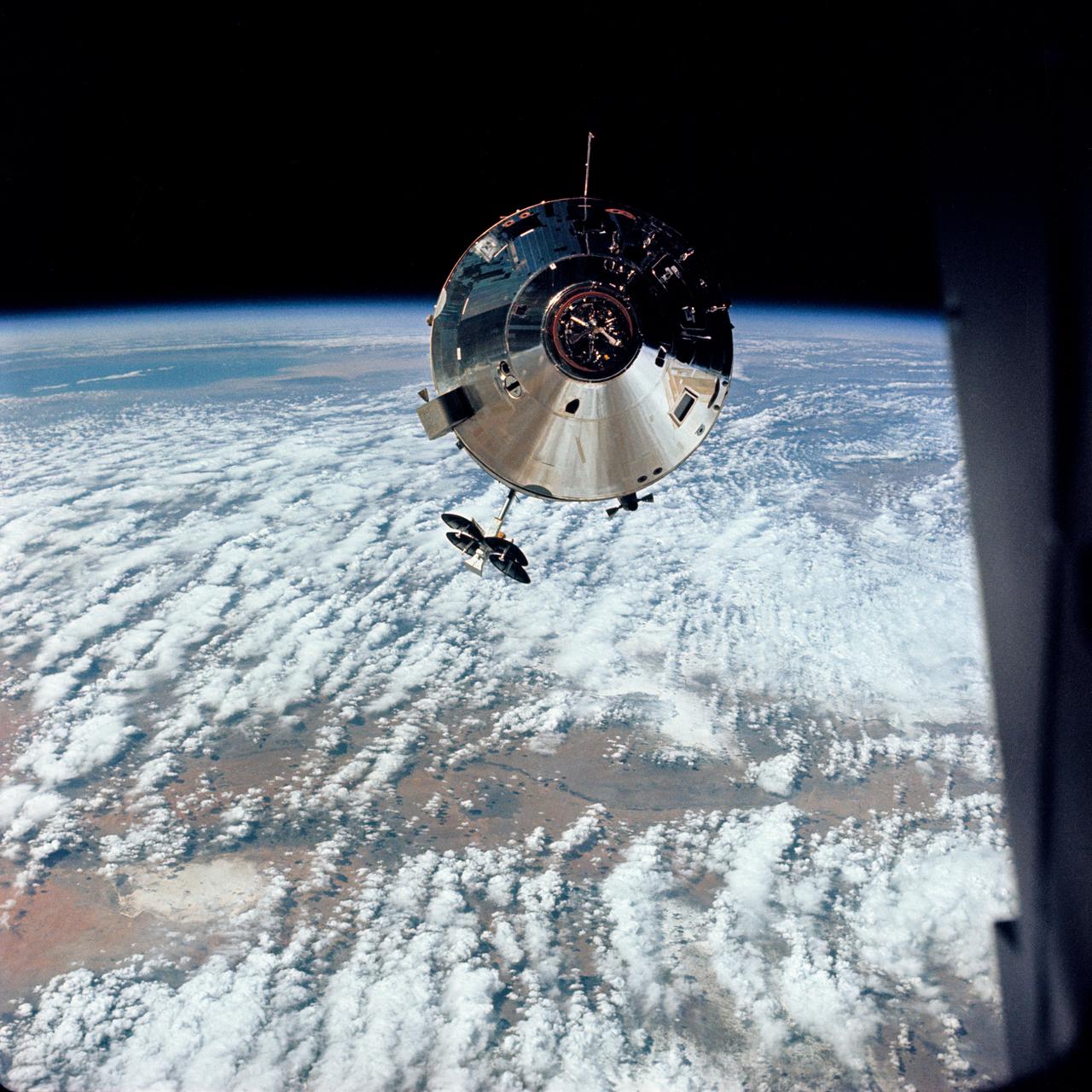 High Oblique photograph (taken over New Mexico) of the Apollo 9 Command/Service Modules taken from the Lunar Module,"Spider",on the fifth day of the Apollo 9 earth-orbital mission. Docking mechanism is visible in nose of the Command Module,"Gumdrop". Object jutting out from the Service Module aft bulkhead is the high-gain S-Band antenna. Film magazine was F, film type was SO-368 Ektachrome with 0.460 - 0.710 micrometers film / filter transmittance response and haze filter,80mm lens. Cloud cover over the Earth is 70%. 