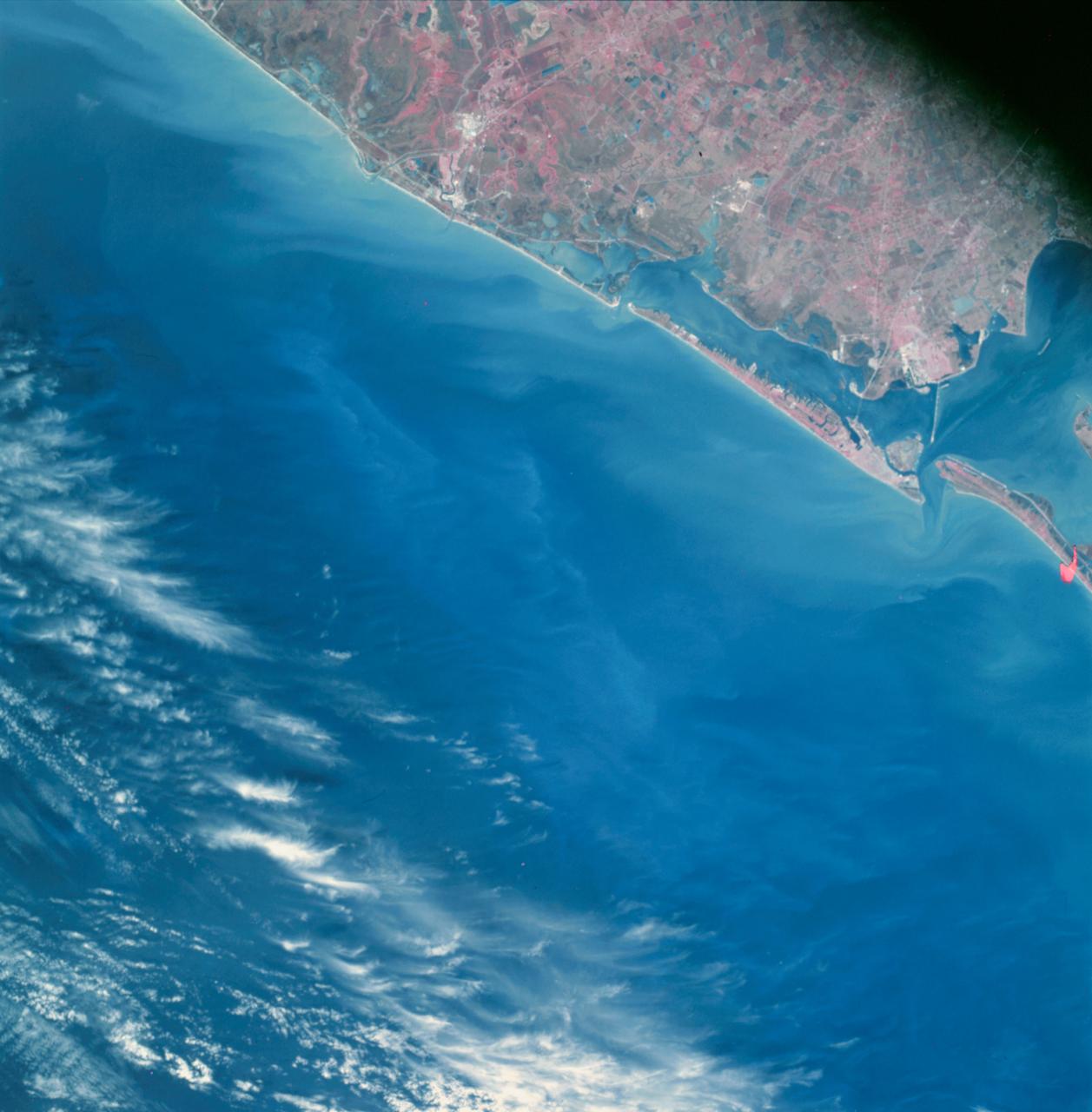 Earth Observation taken by the Apollo 9 crew. View is of Galveston and Freeport in Texas. Latitude was 28.42 N by Longitude 94.54 W, Overlap was 80%, Altitude miles were 105 and cloud cover was 5%. This imagery taken as part of the NASA S0-65 Experiment "Multispectral Terrain Photography". The experiment provides simultaneous satellite photography of the Earth's surface in three distinct spectral bands. The photography consists of four almost spatially identical photographs. The images of ground objects appear in the same coordinate positions on all four photos in the multispectral set within the opto-mechanical tolerances of the Hasselblad cameras in the Apollo 9 spacecraft. Band designation for this frame is A.  Film and filter is Ektachrome SO-368,Infrared Color Wratten 15.  Mean Wavelength of Sensitivity is green,red and infrared. The Nominal Bandpass is total sensitivity of all dye layers 510-900nm.