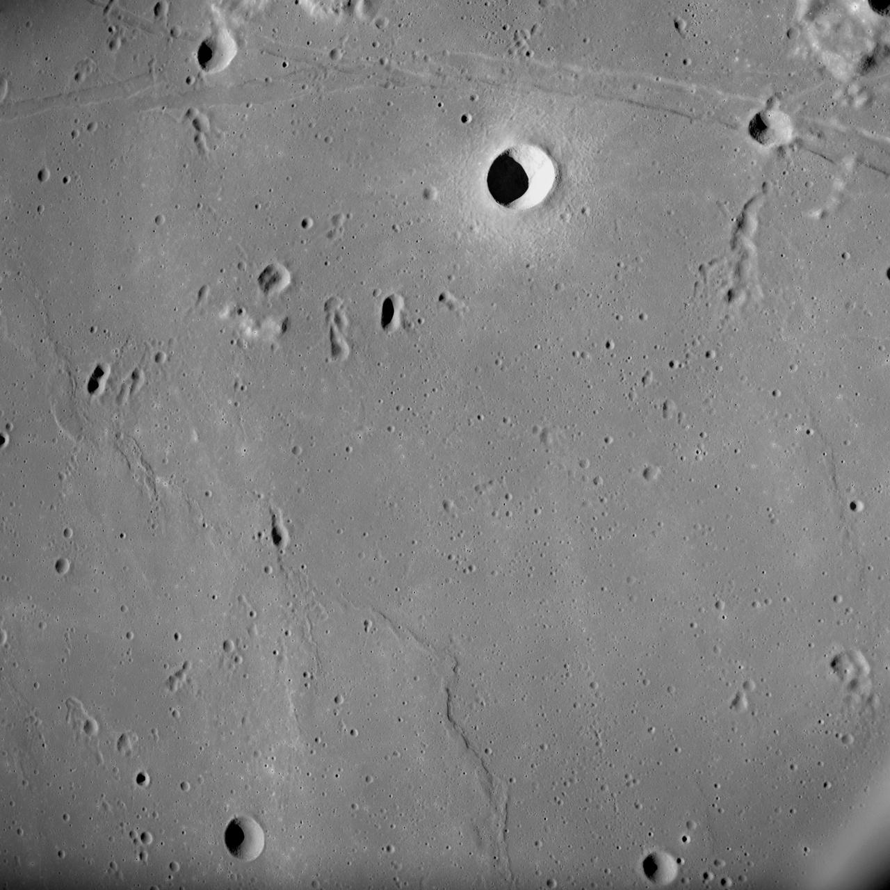 AS10-31-4537 (18-26 May 1969) --- This near vertical photograph taken from the Apollo 10 Command and Service Modules shows features typical of the Sea of Tranquility near Apollo Landing Site 2. HOLD PICTURE WITH PRONOUNCED LINEAR FEATURE PARALLEL TO LEFT MARGIN. The proposed landing area for Apollo 11 (Lunar Landing Site 2) is a relatively smooth maria area in the upper right quadrant of the photographed area. Apollo 10 traveled from the bottom to the top of the picture. The prominent linear feature at left is Hypatia Rille (called "U.S. 1" by the Apollo 10 crew). The prominent crater centered in Hypatia Rille at top left is Moltke AC (code name "Chuck Hole"). Moltke, the prominent crater to the right of Hypatia Rille, is centered near 24.2 degrees east longitude, and 0.6 degrees south latitude.