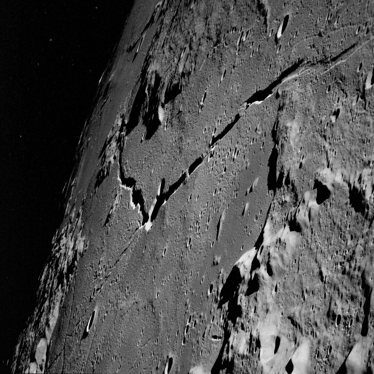 AS10-31-4650 (18-26 May 1969) --- This Apollo 10 oblique telephoto view of the lunar nearside is centered on the crater Hyginus located at 6.3 degrees north latitude, near the northeast margin of Central Bay. HOLD PICTURE WITH SKY AT TOP. The crater is about 10 kilometers (6.5 statue miles) in diameter. From the crater the prominent Hyginus Rille extends east-southeast toward the camera and northwest toward the Sea of Vapors. The rille is about 3 kilometers (2 statue miles) wide and more than 200 kilometers (130 statue miles) long. The horizon is not visible in this photograph, taken from the Command and Service Modules. The sunrise terminator is between the spacecraft and the horizon. At the time this picture was taken Apollo 10 was 325 kilometers (200 statute miles) southeast of Hyginus.