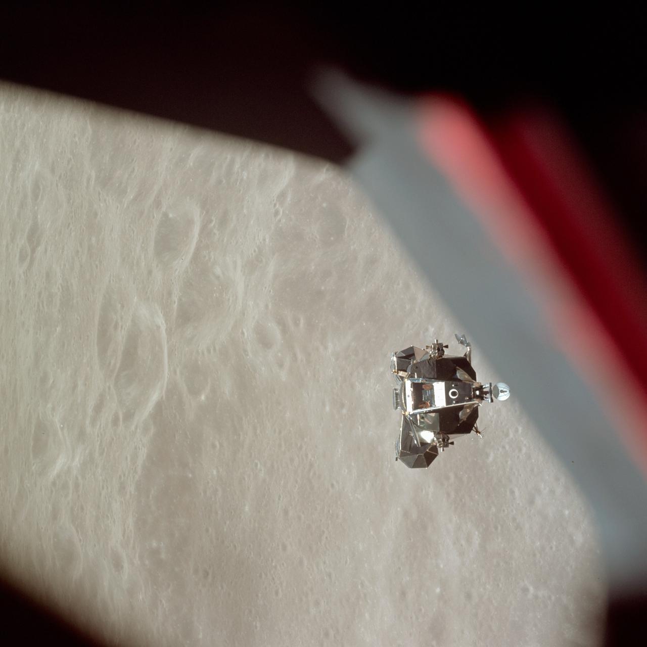 AS10-34-5112 (26 May 1969) --- The ascent stage of the Apollo 10 Lunar Module (LM) is photographed from the Command Module prior to docking in lunar orbit. The LM is approaching the Command and Service Modules from below. The LM descent stage had already been jettisoned. The lunar surface in the background is near, but beyond the eastern limb of the moon as viewed from Earth (about 120 degrees east longitude). The red/blue diagonal line is the spacecraft window.