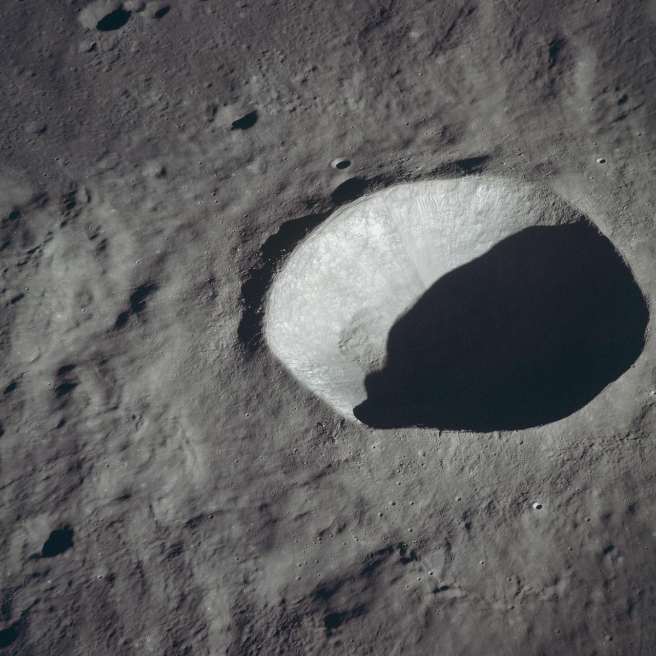 AS10-34-5162 (18-26 May 1969) --- An Apollo 10 view of crater Schmidt which is located at the western edge of the Sea of Tranquility. Schmidt, which has a diameter of 7 statute miles, is also located just south of the crater Ritter and immediately west of the crater Sabine. The coordinates of Schmidt are 18.8 degrees east longitude and 1.2 degrees north latitude. The shadowed area is on the east side of the crater.