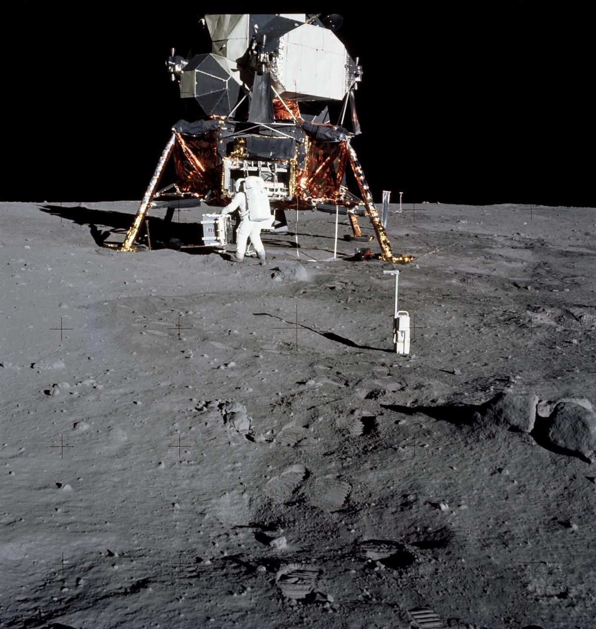 AS11-40-5931 (20 July 1969) --- Astronaut Edwin E. Aldrin Jr., lunar module pilot, prepares to deploy the Early Apollo Scientific Experiments Package (EASEP) on the surface of the moon during the Apollo 11 extravehicular activity. Astronaut Neil A. Armstrong, commander, took this photograph with a 70mm lunar surface camera. In the foreground is the Apollo 11 35mm stereo close-up camera.