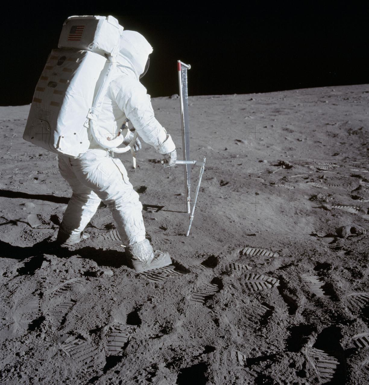 AS11-40-5964 (20 July 1969) --- Astronaut Edwin E. Aldrin Jr., lunar module pilot, is photographed during the Apollo 11 extravehicular activity (EVA) on the moon. He is driving one of two core tubes into the lunar soil. Astronaut Neil A. Armstrong, commander, took this picture with a 70mm lunar surface camera. Aldrin stands near the Solar Wind Composition (SWC) experiment, a component of the Early Apollo Scientific Experiments Package (EASEP, deployed earlier). The SWC is in the center background.