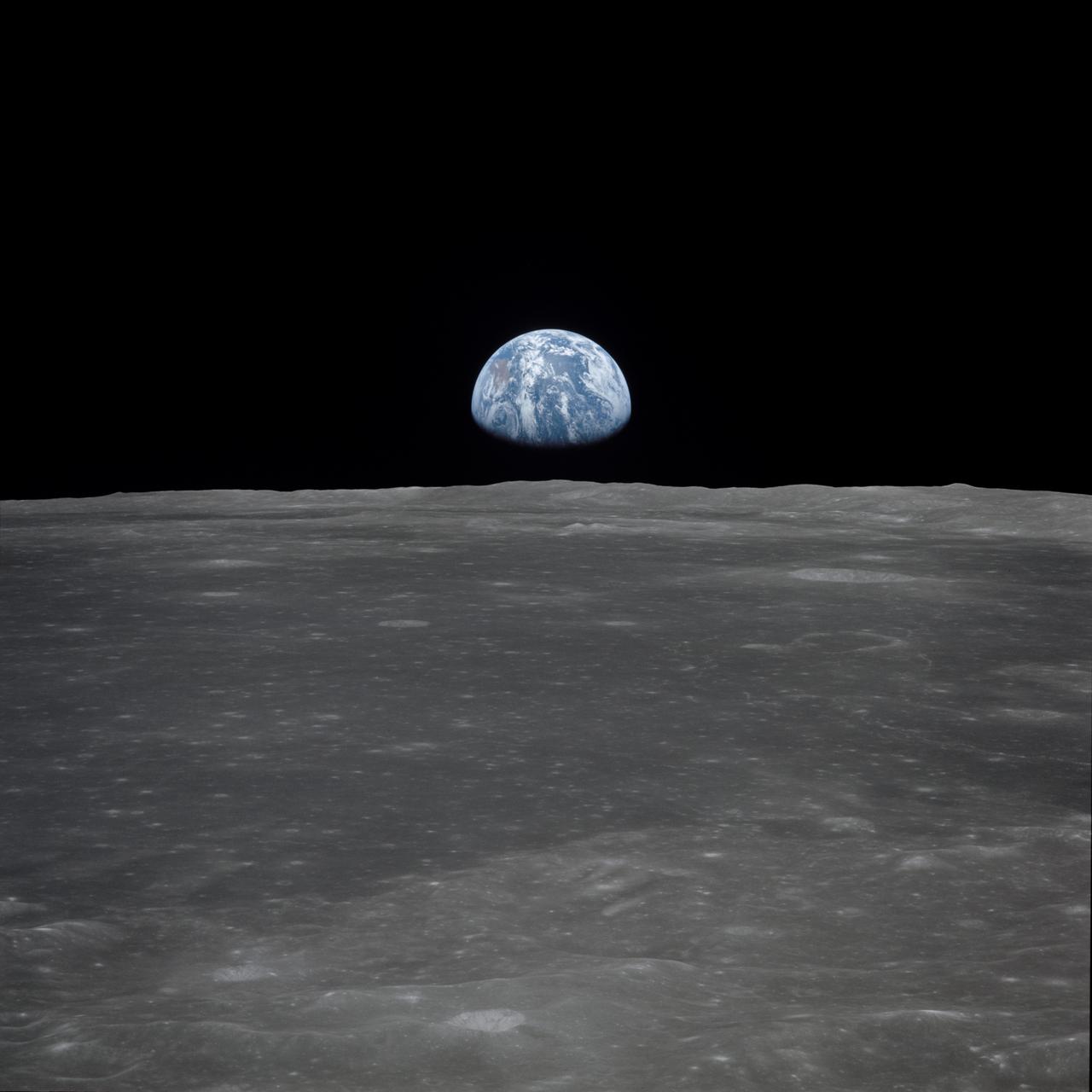 AS11-44-6550 (16-24 July 1969) --- This view from the Apollo 11 spacecraft shows Earth rising above the moon's horizon. The lunar terrain pictured is in the area of Smyth's Sea on the nearside. Coordinates of the center of the terrain are 86 degrees east longitude and 3 degrees north latitude. While astronauts Neil A. Armstrong, commander, and Edwin E. Aldrin Jr., lunar module pilot, descended in the Lunar Module (LM) "Eagle" to explore the Sea of Tranquility region of the moon, astronaut Michael Collins, command module pilot, remained with the Command and Service Modules (CSM) "Columbia" in lunar orbit. Apollo 11 was NASA's first lunar landing mission in the Apollo program.