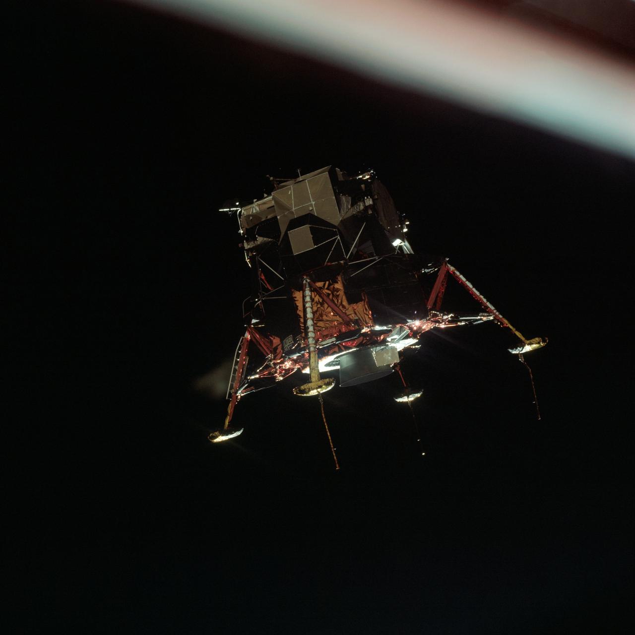 AS11-44-6581 (20 July 1969) --- The Apollo 11 Lunar Module (LM), in a lunar landing configuration, is photographed in lunar orbit from the Command and Service Modules (CSM).  Inside the LM were astronauts Neil A. Armstrong, commander, and Edwin E. Aldrin Jr., lunar module pilot.  Astronaut Michael Collins, command module pilot, remained with the CSM in lunar orbit while Armstrong and Aldrin descended in the LM to explore the lunar surface.  The protrusions connected to the landing pods are sensors to aid in the touchdown or landing process.