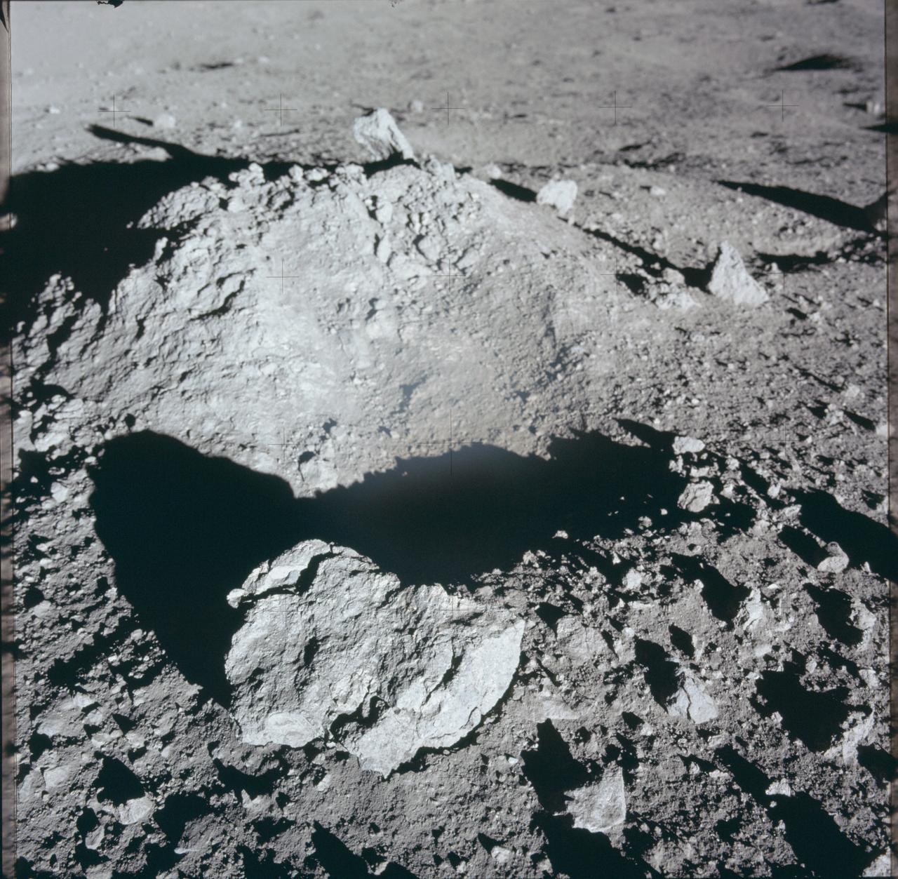 AS12-46-6825 (19 Nov. 1969) --- Close-up view of a lunar rock, small crater, and lunar mound as photographed during the Apollo 12 extravehicular activity (EVA). Astronaut Richard F. Gordon Jr., command module pilot, remained with the Apollo 12 Command and Service Modules (CSM) in lunar orbit while astronauts Charles Conrad Jr., commander, and Alan L. Bean, lunar module pilot, descended in the Lunar Module (LM) to explore the moon.