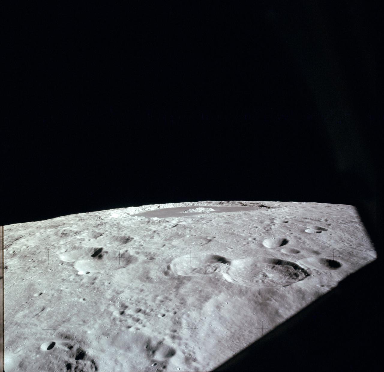 AS12-47-6870 (November 1969) --- An Apollo 12 high-oblique view of the crater Tsiolkovsky (in center of horizon) on the lunar farside, as photographed from lunar orbit. The crew men of the Apollo 12 lunar landing mission were astronauts Charles Conrad Jr., commander; Richard F. Gordon Jr., command module pilot; and Alan L. Bean, lunar module pilot. Tsiolkovsky is centered at 128.5 degrees east longitude and 20.5 degrees south latitude. This view is looking south.
