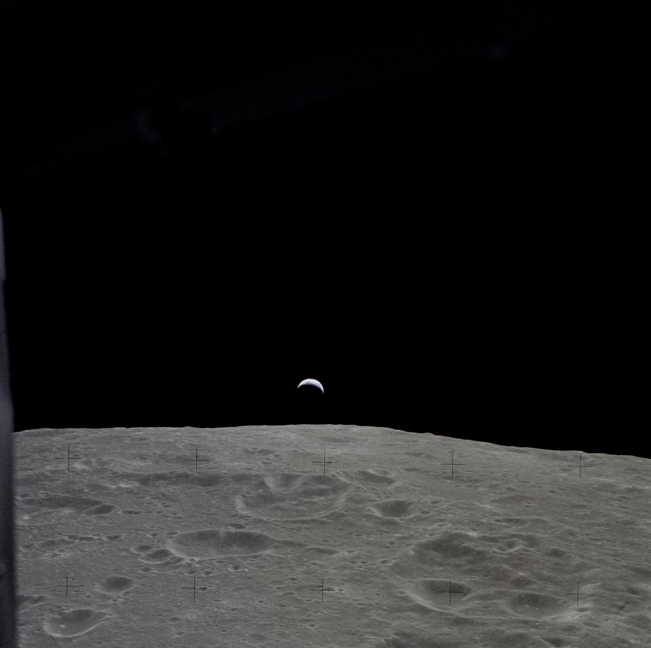 AS12-47-6891 (14-24 Nov. 1969) --- A partially illuminated Earth rises above the lunar horizon in this photograph taken from the Apollo 12 spacecraft in lunar orbit.