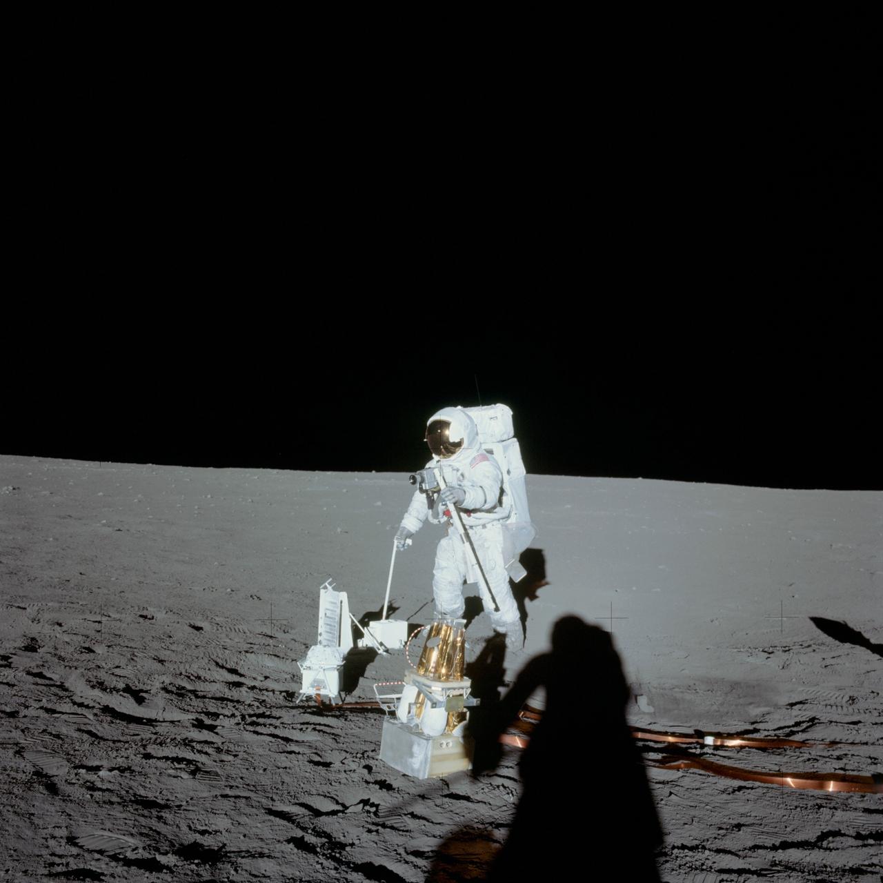 AS12-47-6919 (19 Nov. 1969) --- Astronaut Alan L. Bean, lunar module pilot, deploys components of the Apollo Lunar Surface Experiments Package (ALSEP) during the first Apollo 12 extravehicular activity (EVA) on the moon. The photo was made by astronaut Charles Conrad Jr., commander, using a 70mm handheld Hasselblad camera modified for lunar surface usage.