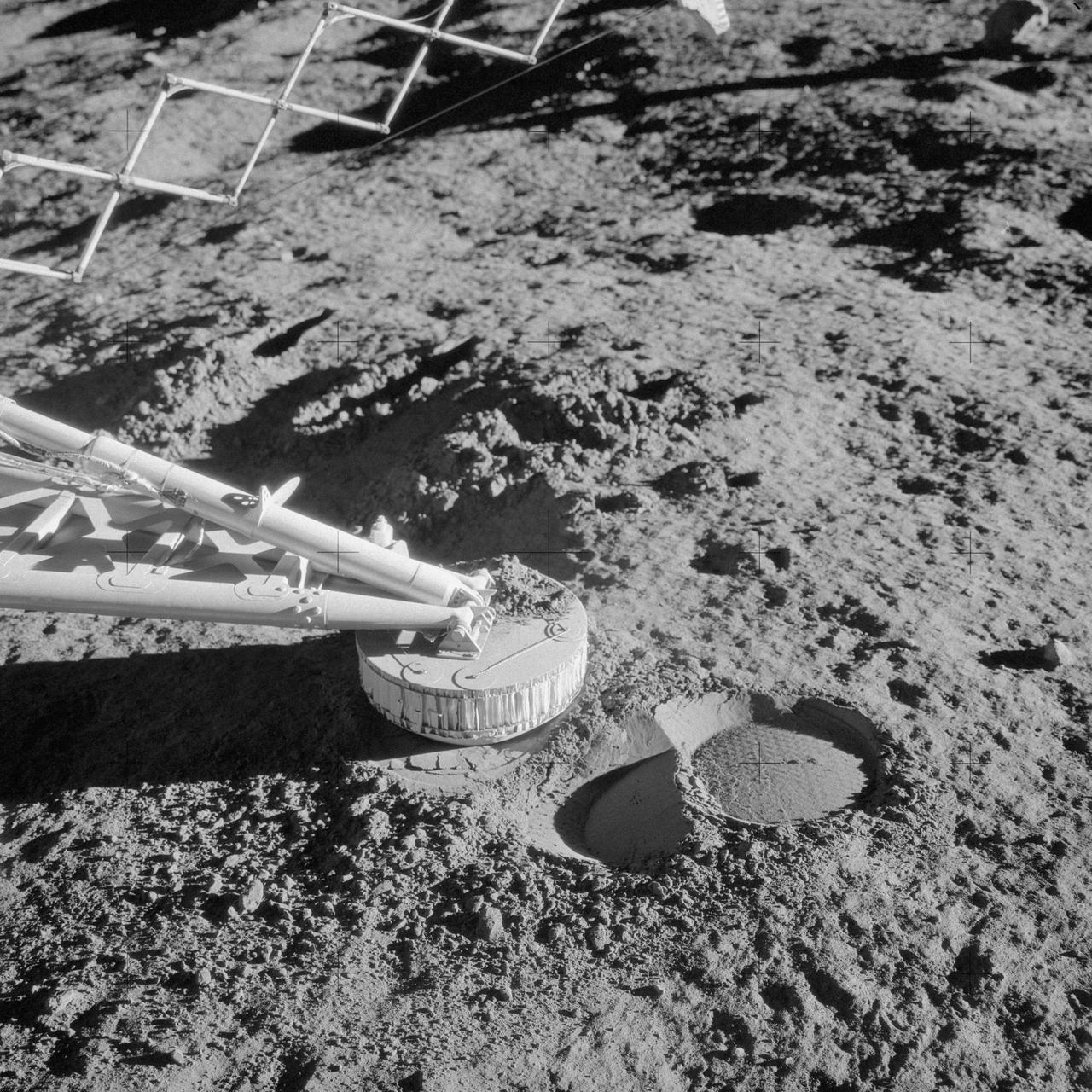 AS12-48-7110 (20 Nov. 1969) --- A close-up view of a footpad and surface sampler with scoop (arm, out of frame) on the Surveyor 3 spacecraft which was photographed by the Apollo 12 astronauts during their second extravehicular activity (EVA) on the moon. The Apollo 12 Lunar Module (LM), with astronauts Charles Conrad Jr. and Alan L. Bean aboard, touched down in the Ocean of Storms only 600 feet from Surveyor 3. The television camera and several other pieces were taken from Surveyor 3 and brought back to Earth for scientific examination. The unmanned spacecraft soft-landed on the moon on April 19, 1967. Note the imprint in the lunar soil which was caused when the Surveyor 3 bounced upon landing.