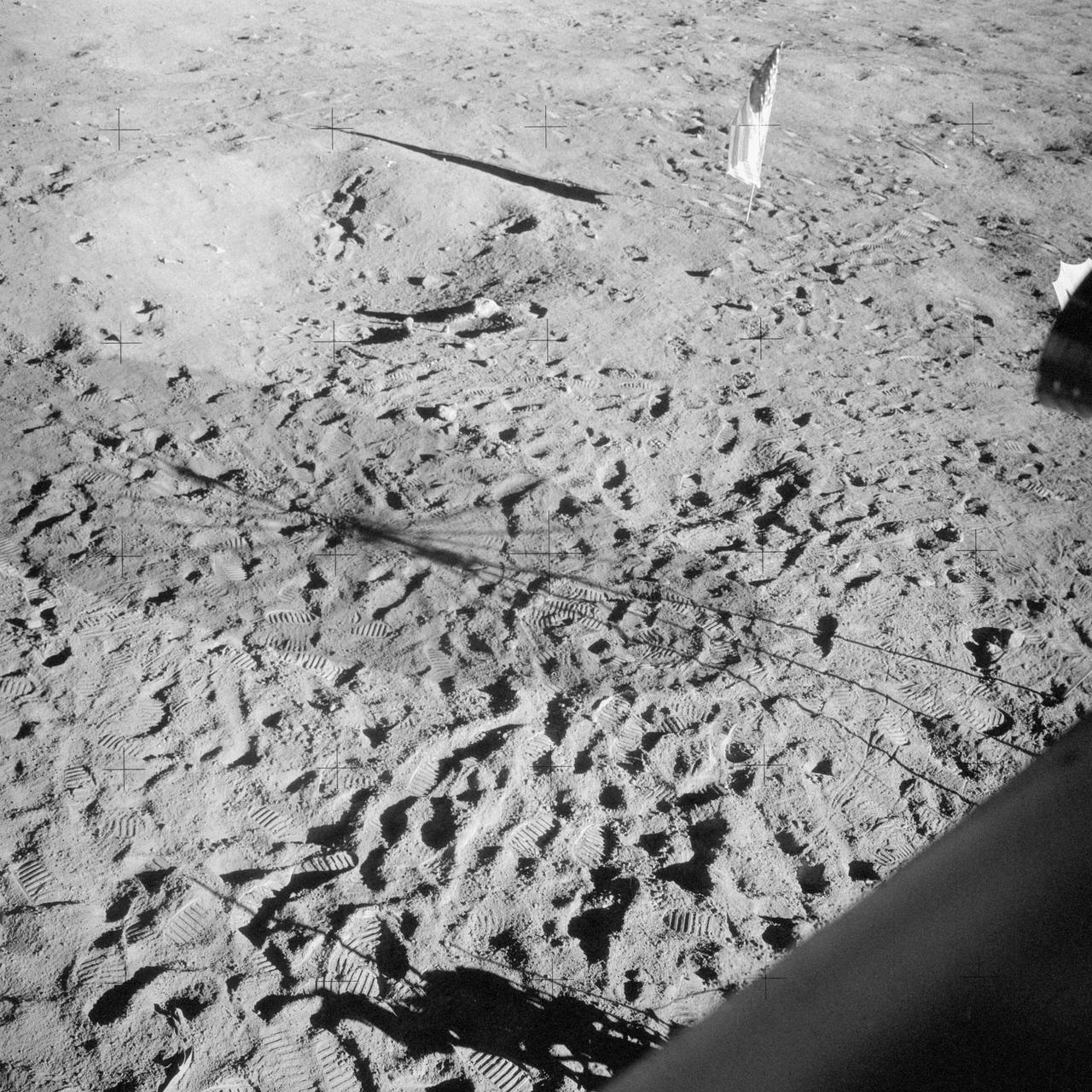 AS12-48-7160 (19-20 Nov. 1969) --- This view of the lunar surface was taken by one of the two astronauts on the Apollo 12 mission during their extravehicular activity. Seen in this view are the U.S. flag, several astronaut footprints, and a small crater near their Lunar Module landing site. Astronaut Charles Conrad Jr., commander, and Alan L. Bean, lunar module pilot, descended in the Lunar Module to explore the lunar surface. Astronaut Richard F. Gordon Jr., command module pilot, remained with Command and Service Modules in lunar orbit.