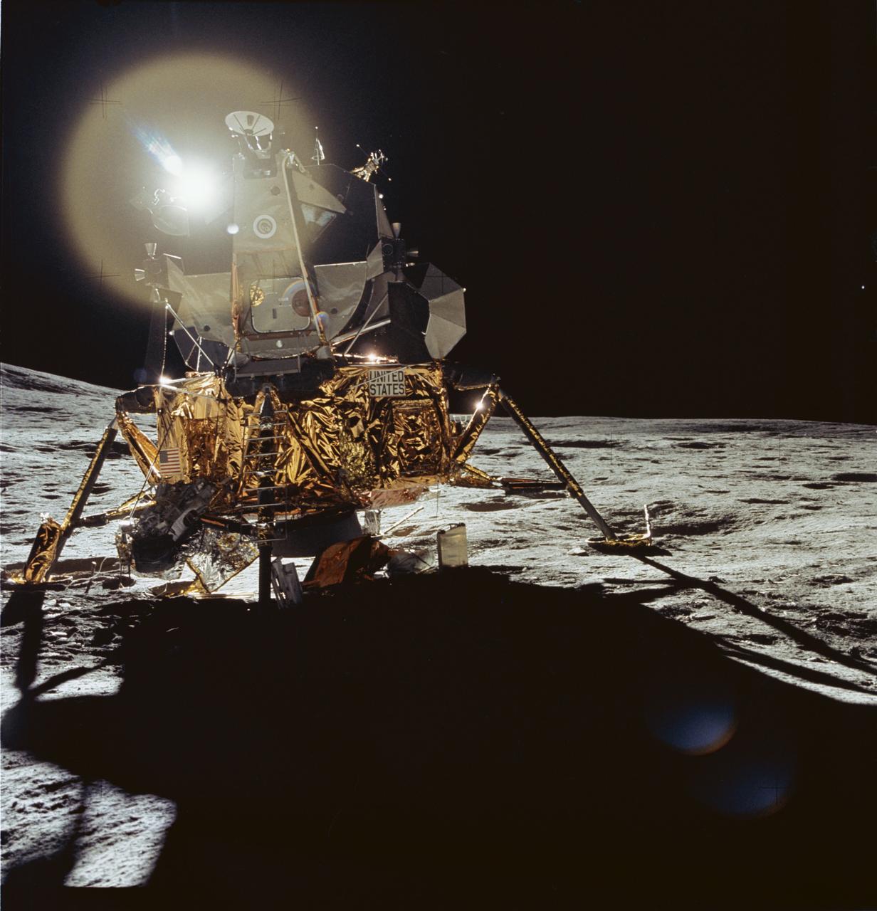 AS14-66-9306 (5 Feb. 1971) --- A front view of the Apollo 14 Lunar Module (LM), which reflects a circular flare caused by the brilliant sun, as seen by the two moon-exploring crew men of the Apollo 14 lunar landing mission during their first extravehicular activity (EVA). The unusual ball of light was said by the astronauts to have a jewel-like appearance. At the extreme left the lower slope of Cone Crater can be seen. Astronauts Alan B. Shepard Jr., commander; and Edgar D. Mitchell, lunar module pilot; descended in the LM, while astronaut Stuart A. Roosa, command module pilot; remained with the Command and Service Modules (CSM) in lunar orbit.