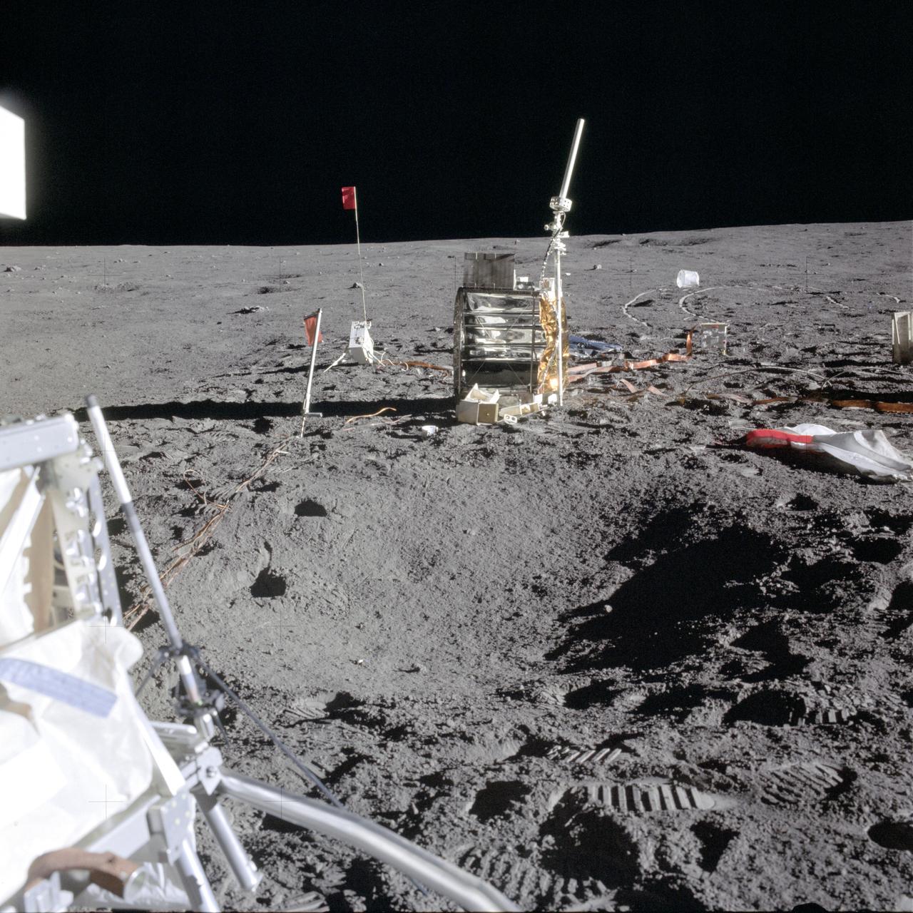 AS14-67-9376 (5 Feb. 1971) --- Several components of the Apollo lunar surface experiments package (ASLEP) are deployed in this photograph taken during the first Apollo 14 extravehicular activity (EVA). The larger object with antenna is the ALSEP central station (CS). The active seismic experiment (ASE) mortar package assembly is to the rear left of the CS. The charged particle lunar environment experiment (CPLEE) is to the right rear of the CS. A portion of the modularized equipment transporter (MET) can be seen in the left foreground.
