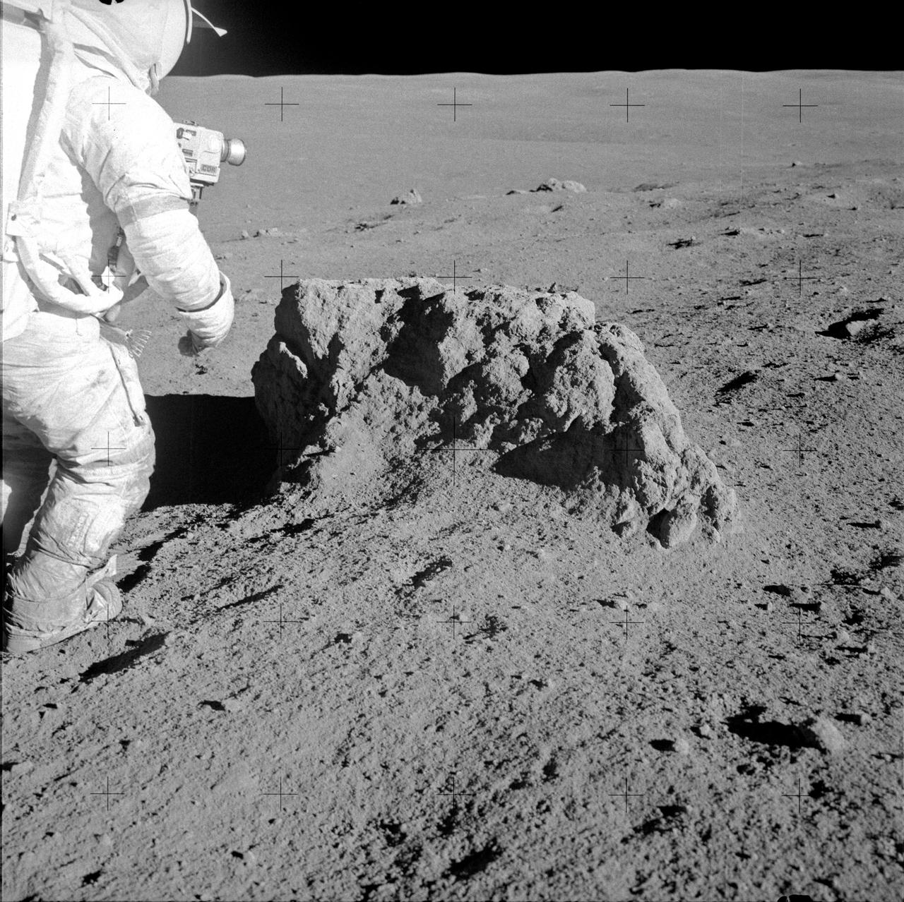 AS14-68-9414 (6 Feb. 1971) --- Astronaut Alan B. Shepard Jr., Apollo 14 commander, stands beside a large boulder on the lunar surface during the mission's second extravehicular activity (EVA), on Feb. 6, 1971. Note the lunar dust clinging to Shepard's space suit. Astronauts Shepard and Edgar D. Mitchell, lunar module pilot, explored the lunar surface while astronaut Stuart A. Roosa, command module pilot, orbited the moon in the Command and Service Modules (CSM).