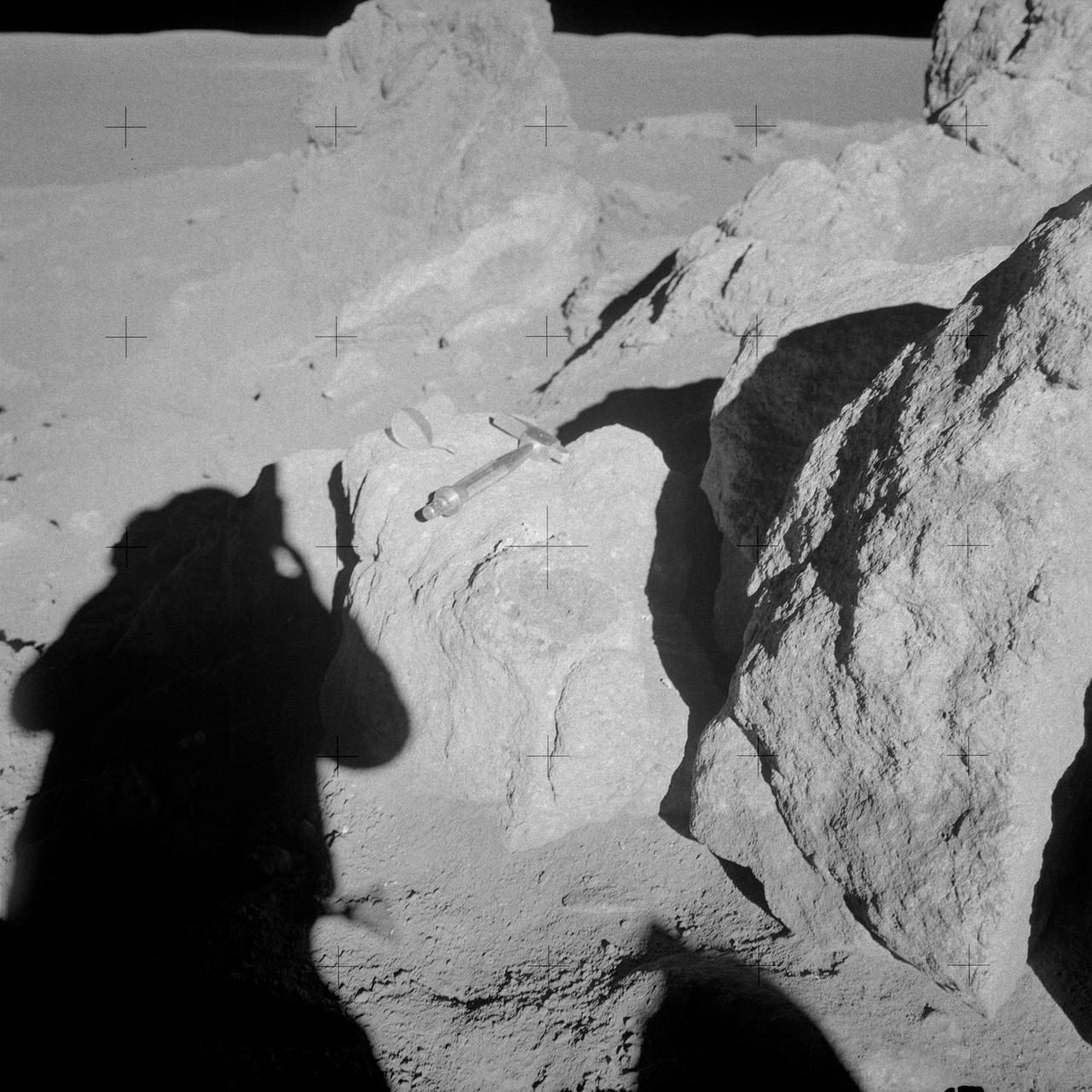 AS14-68-9453 (6 Feb. 1971) --- Astronaut Edgar D. Mitchell, lunar module pilot, whose shadow is in the foreground, photographs a group of large boulders near the rim of Cone Crater. An interesting feature is the white and brown rock in the boulder. Mitchell removed a sample where the hammer is lying. While astronauts Alan B. Shepard Jr., commander, and Mitchell descended in the Lunar Module (LM) "Antares" to explore the Fra Mauro region of the moon, astronaut Stuart A. Roosa, command module pilot, remained with the Command and Service Modules (CSM) "Kitty Hawk" in lunar orbit.