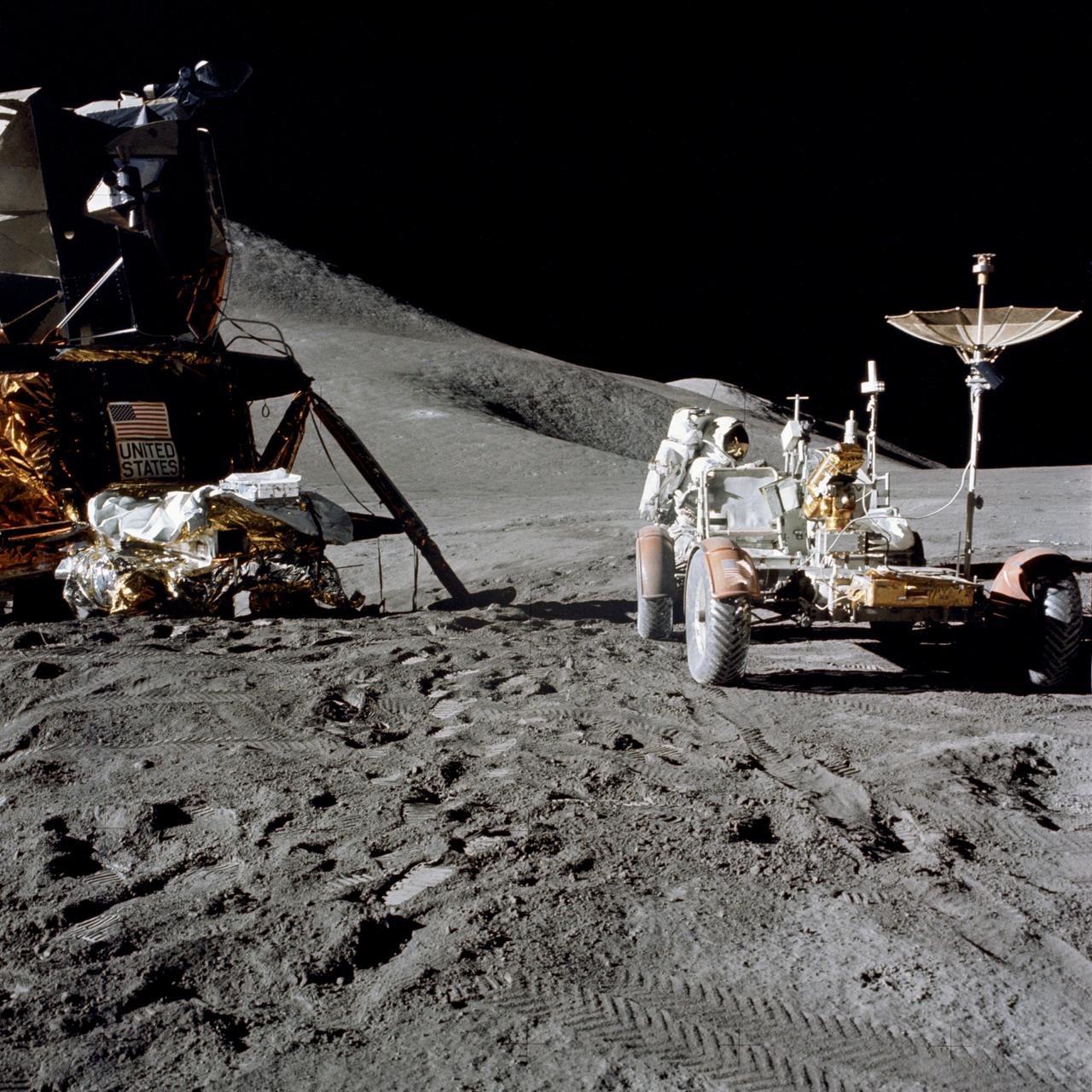 AS15-86-11602 (31 July 1971) --- Astronaut James B. Irwin, lunar module pilot, works at the Lunar Roving Vehicle (LRV) during the first Apollo 15 lunar surface extravehicular activity (EVA) at the Hadley-Apennine landing site. A portion of the Lunar Module (LM) "Falcon" is on the left. The undeployed Laser Ranging Retro Reflector (LR-3) lies atop the LM's modular equipment stowage assembly (MESA). This view is looking slightly west of south. Hadley Delta and the Apennine Front are in the background to the left. St. George crater is approximately five kilometers (about three statute miles) in the distance behind Irwin's head. This photograph was taken by astronaut David R. Scott, commander. While astronauts Scott and Irwin descended in the LM to explore the moon, astronaut Alfred M. Worden, command module pilot, remained with the Command and Service Modules (CSM) in lunar orbit.
