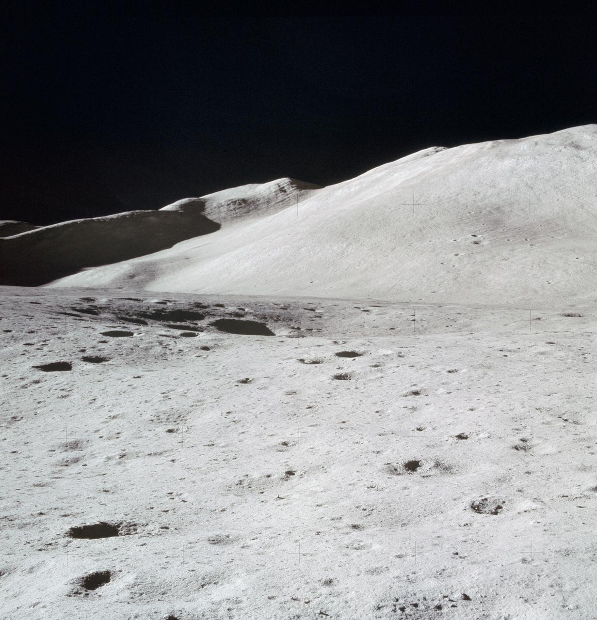 AS15-87-11748 (31 July 1971) --- A view of Hadley Delta, looking southeasterly, as photographed from the top hatch of the Apollo 15 Lunar Module (LM) by astronaut David R. Scott, commander, during his stand-up extravehicular activity (EVA) just after the LM "Falcon" touched down at the Hadley-Apennine landing site. The prominent feature on the horizon in the center of the picture was called Silver Spur by the Apollo 15 crew men. Hadley Delta Mountain rises approximately 4,000 meters (about 13,124 feet) above the plain. While astronauts Scott and James B. Irwin, lunar module pilot, descended in the LM to explore the moon, astronaut Alfred M. Worden, command module pilot, remained with the Command and Service Module's (CSM) in lunar orbit.