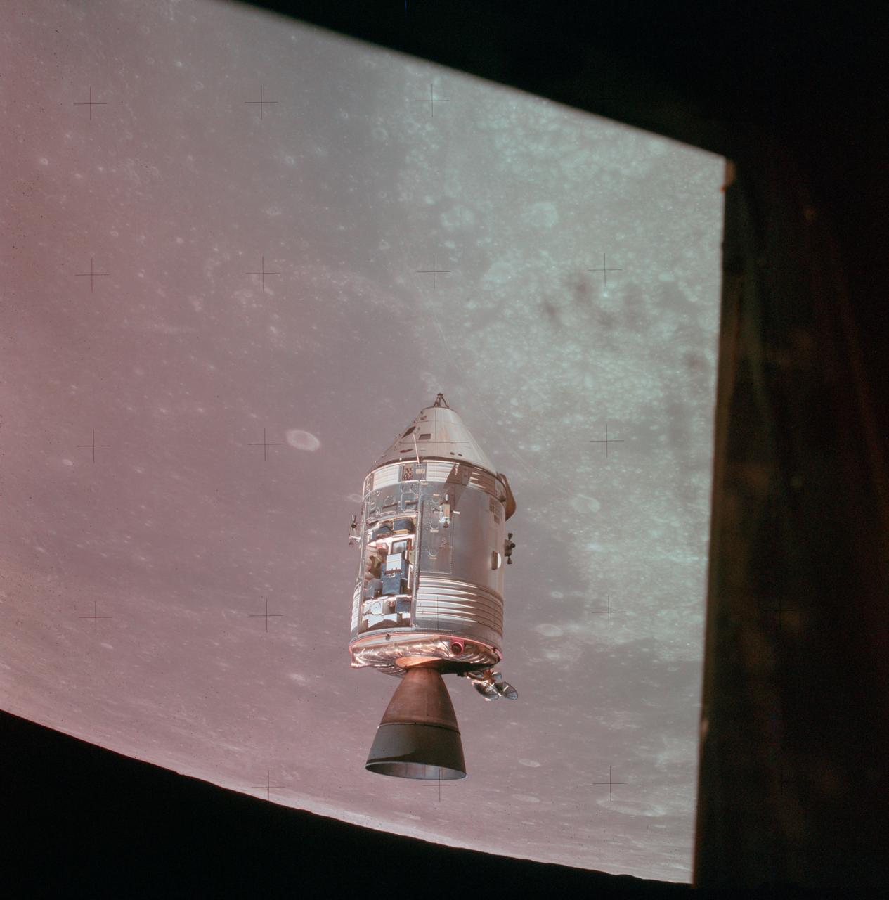 AS15-88-11969 (30 July 1971) --- A view of the Apollo 15 Command and Service Modules (CSM) in lunar orbit as photographed from the Lunar Module (LM) just after rendezvous. The lunar nearside is in the background. This view is looking southeast into the Sea of Fertility. The crater Taruntius is at the right center edge of the picture.