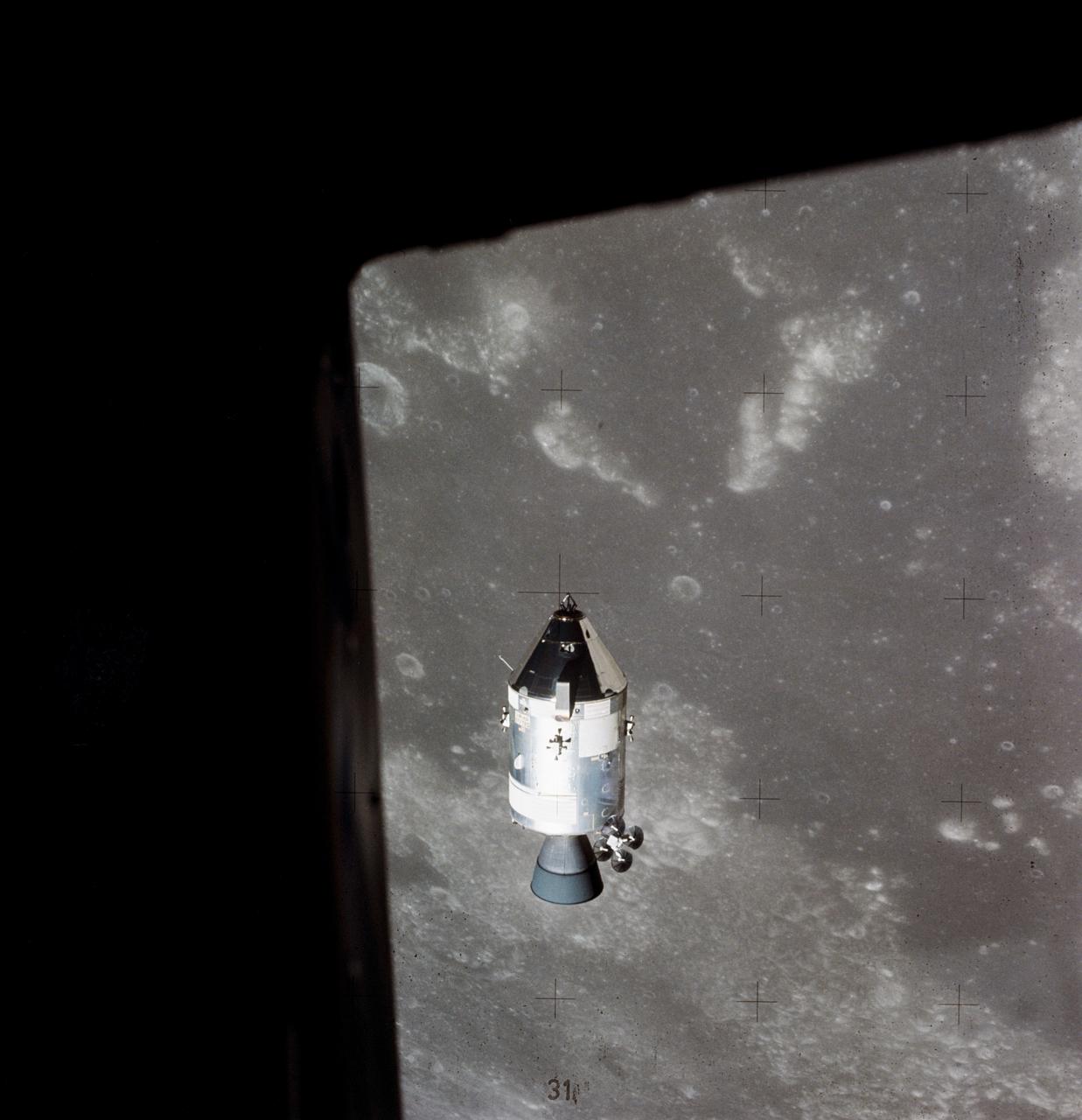 AS15-88-11974 (30 July 1971) --- A view of the Apollo 15 Command and Service Modules (CSM) in lunar orbit as photographed from the Lunar Module (LM) just after rendezvous. The lunar nearside is in the background. This view is looking southeast into the Sea of Fertility. The crater Taruntius is at the right center edge of the picture.