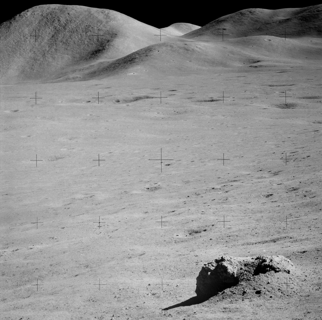 AS15-90-12187 (31 July-2 Aug. 1971) --- This view, looking generally north, shows the tall Mount Hadley in the left background. The photograph was taken from the slope of Hadley Delta during Apollo 15 extravehicular activity (EVA). The crewmen of Apollo 15 noted the visible layering feature of the mountain. Note boulder in foreground. Mount Hadley rises approximately 14,765 feet (about 4,500 meters) above the plain.
