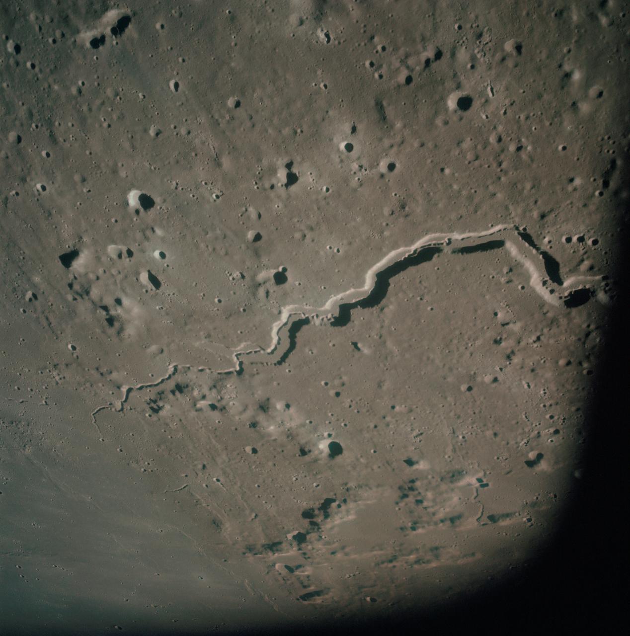 AS15-93-12628 (31 July 1971) --- The snake-like rille feature in this 70mm frame, photographed from the lunar-orbiting Apollo 15 Command and Service Modules (CSM) by astronaut Alfred M. Worden, command module pilot, is Schroter's Valley. The long feature is located not far from the crater Aristarcus (out of frame) on the western side of the moon. Center coordinates of the area pictured are located at 25 degrees north latitude and 52.5 degrees west longitude. While astronauts David R. Scott, commander, and James B. Irwin, lunar module pilot, descended in the Lunar Module (LM) "Falcon" to explore the Hadley-Apennine area of the moon, astronaut Worden remained with the CSM in lunar orbit.